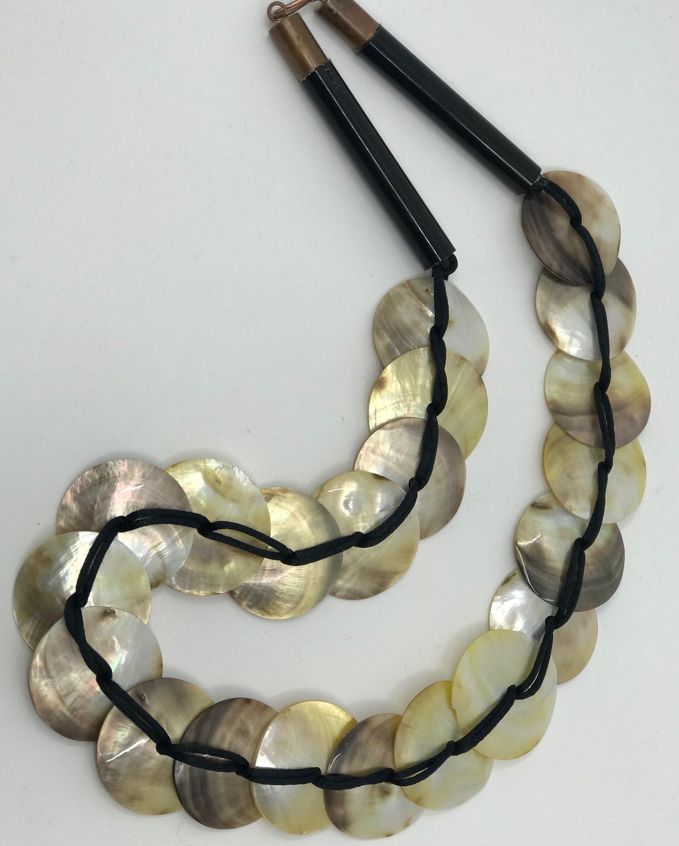  Mother of pearl Necklace consists of  Pinctada Margaritifera circles connected with a silk thread and finished with black acrylic tubes and copper closures. This necklace can be worn on two sides . The Silver side is the inside of the shell. The