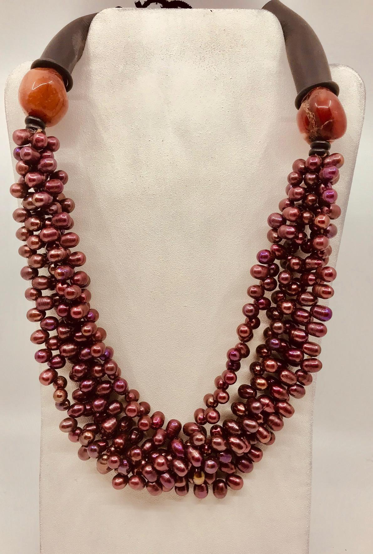 Burgundy color 4 strand Pearl Necklace is enhanced by large Carnelian beads and finished with rubber tubes for comfort.	
 Pearls are the only gems created by an oyster – a living organism. Today, most pearls are grown on aquaculture farms. The white