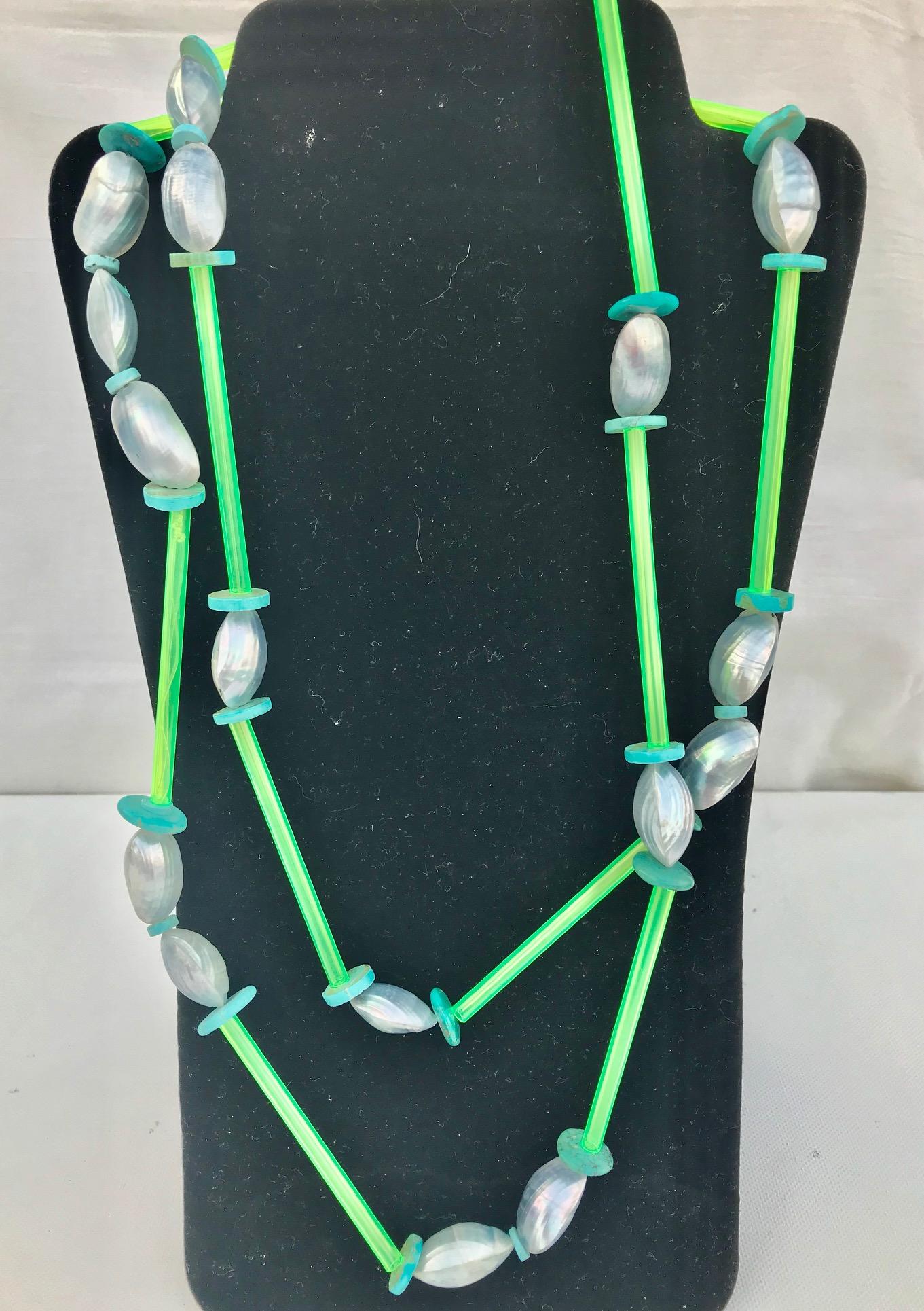 Two necklaces composed of
 1..Carved  Turquoise ,beads  with florescent green acrylic spacers,  extra long . 
2.  The second necklace is composed of the beads made from inside of the Nautilus shell and blue acrylic and small turquoise beads 