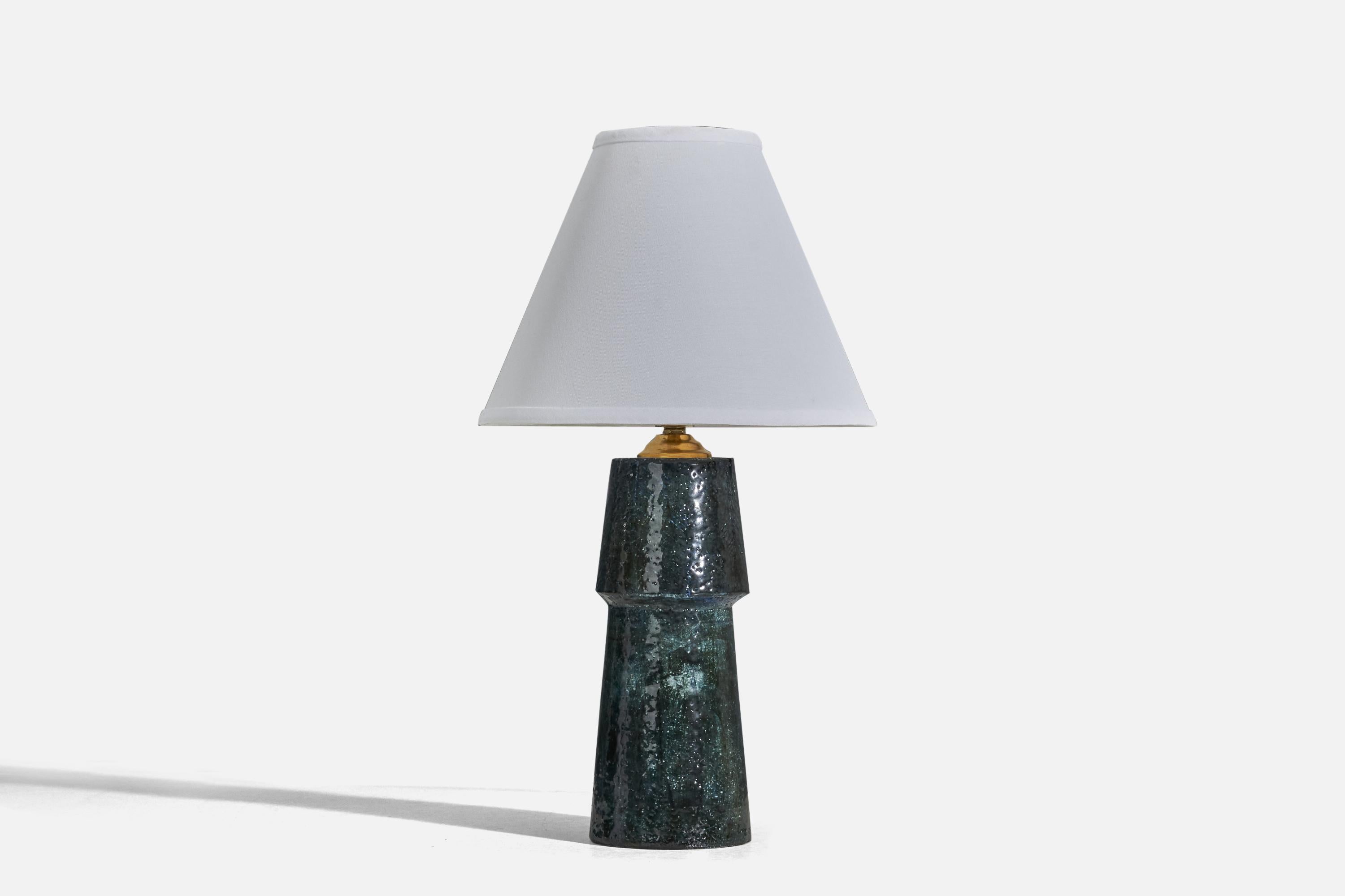 A blue glazed stoneware and brass table lamp designed by Sylvia Leuchovius and produced by Rörstrand, Sweden, 1960s.

Sold without Lampshade
Dimensions of Lamp (inches) : 13.25 x 4.10 x 4.10 (Height x Width x Depth)
Dimensions of Lampshade