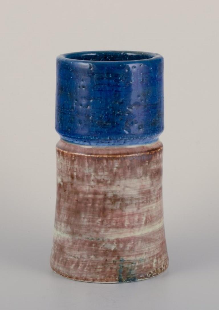 Sylvia Leuchvius (1915–2003) for Rörstrand, Sweden. 
Ceramic vase with glaze in blue and sandy tones.
From the 1960s.
Signed.
In perfect condition.
Dimensions: Height 16.5 cm x Diameter 9.0 cm.

Sylvia Leuchovius stood out as one of the preeminent