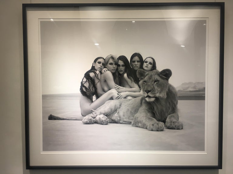 Sylvie Blum Black and White Photograph - The lion king- group portrait of nude models, posing with a lion in the desert