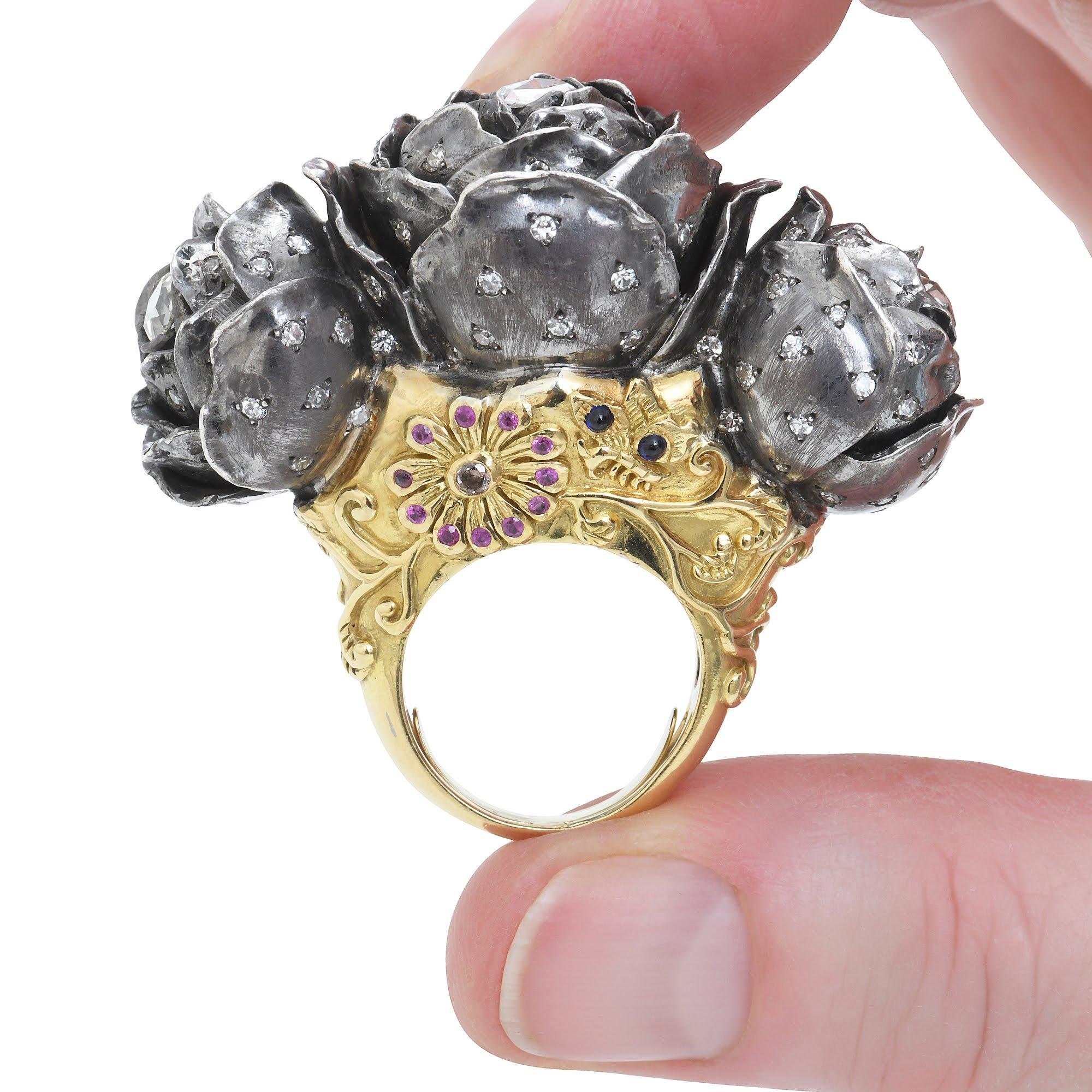 Ring in yellow 18K gold and sterling silver. The three roses are in silver with white diamonds and rose cut diamonds. The ring's mount is in 18K gold and some flowers are carved in relief. 