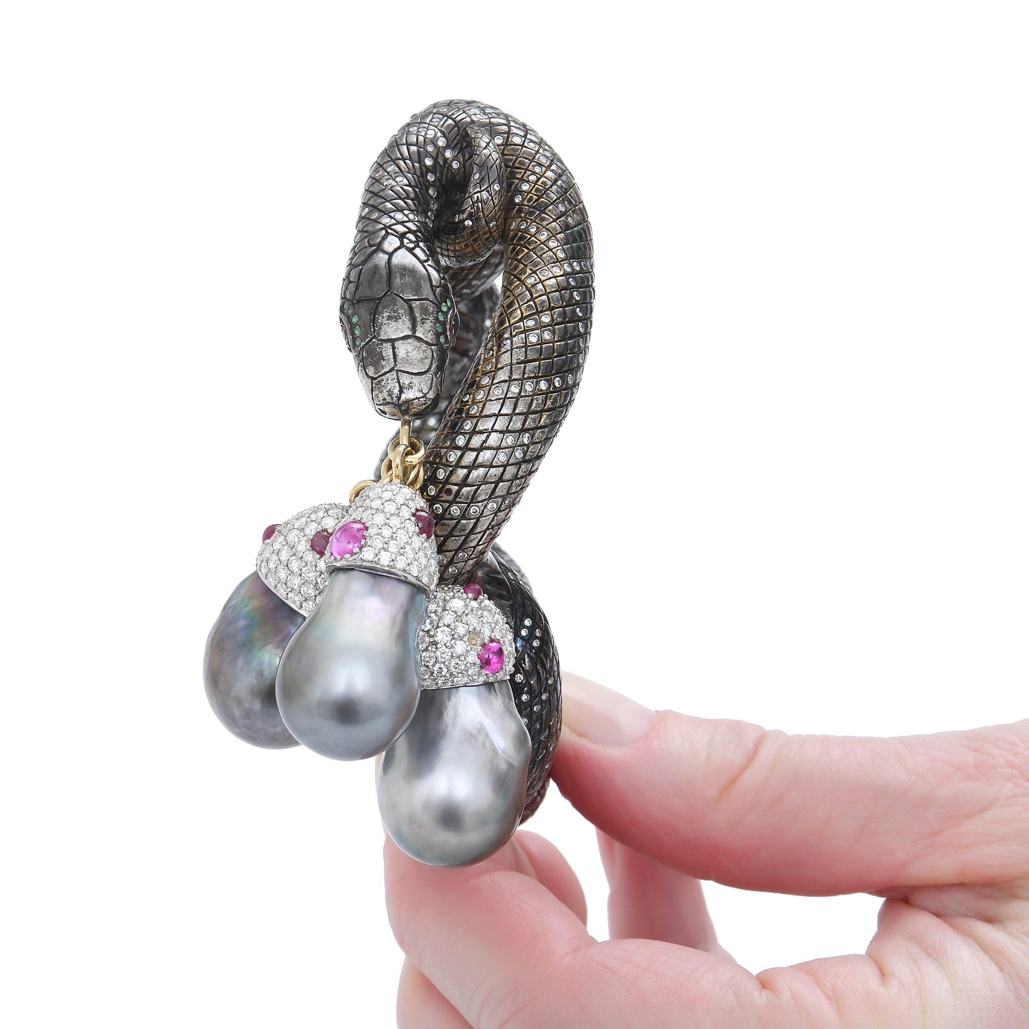Bracelet in form of a twisted snake in rodium silver and black gold adorn with diamonds. 
From the mouth three baroque south-sea pearls with a diamonds top are suspended.
White diamonds : 11,97 cts
South sea pearls : 133,8 cts