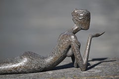 Passione - Una scultura in bronzo raffigurante una donna nuda e sdraiata che si bacia.