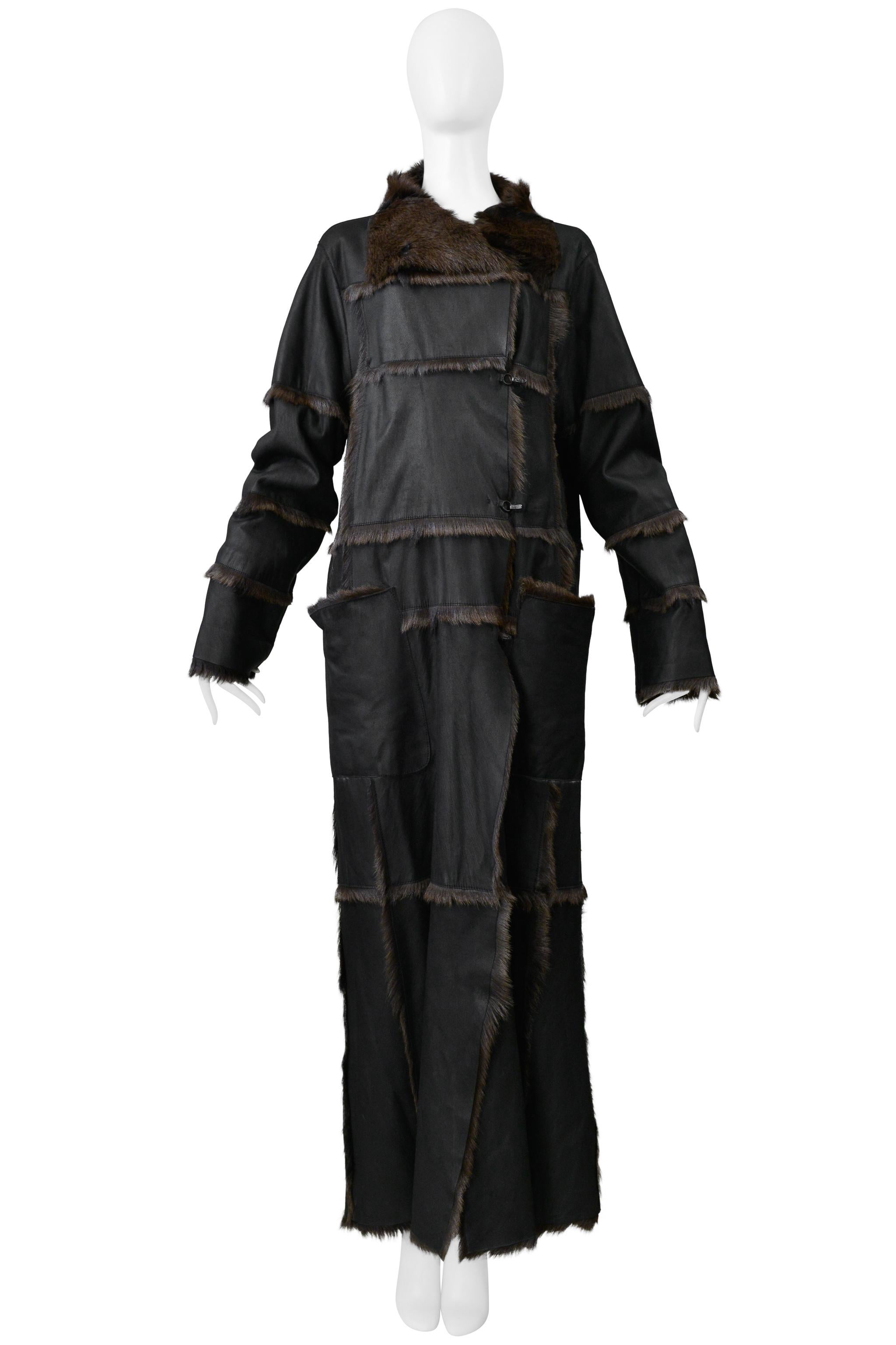 Resurrection Vintage a le plaisir de vous proposer un magnifique manteau maxi en fourrure de chèvre noire par Sylvie Coates, avec des fermetures à fermoir, une coupe oversize, de grandes poches plaquées, un col en fourrure, du cuir noir avec des