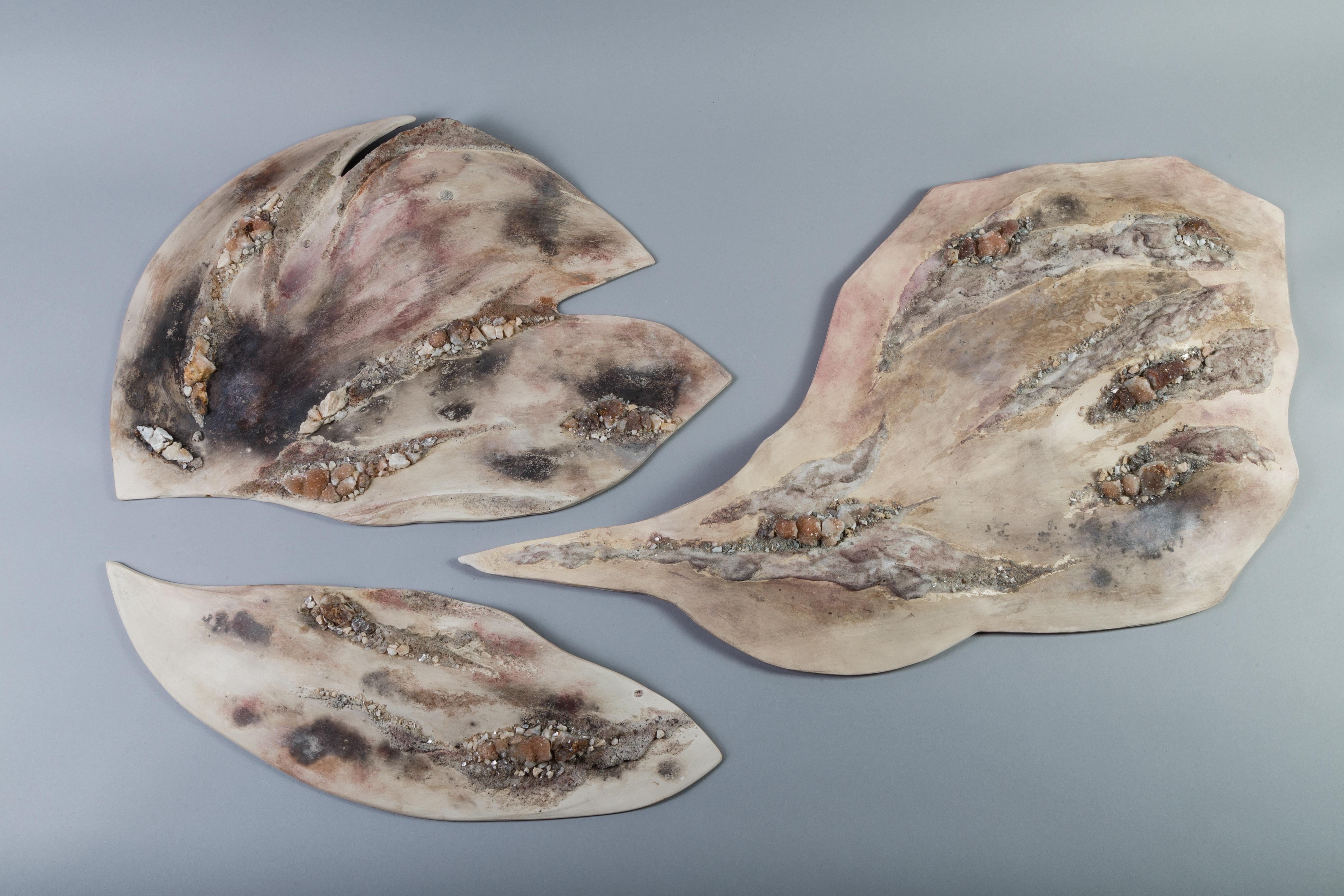 Symbiosis II is a 3 part Earthenware wall panel by French ceramicist Claire Frechet. The work in a one-off handcrafted form made of polished earthenware with varied glazes, mixed volcanic sands, additionally applied patinas, and hand applied quartz
