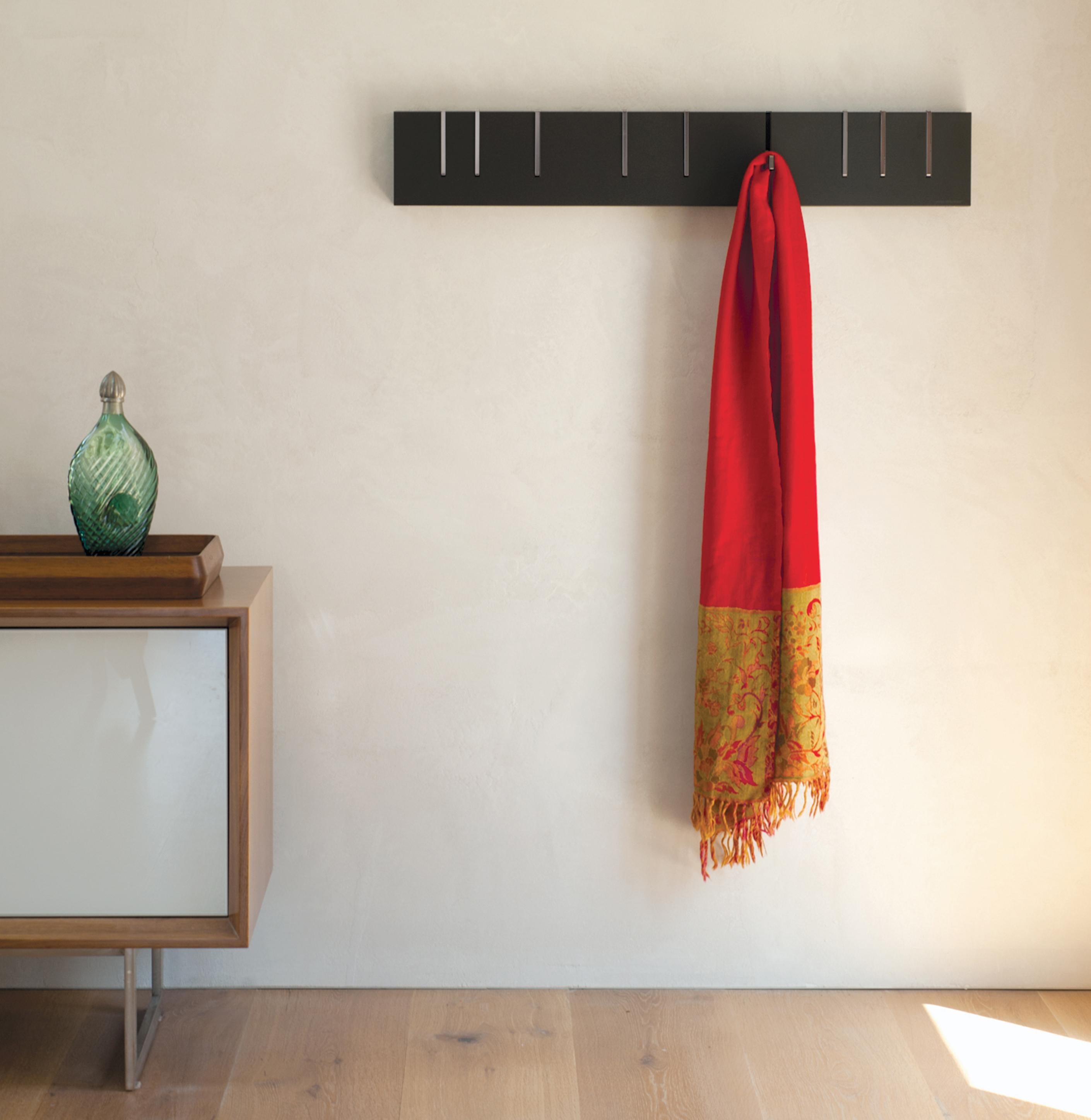 The iconic coat rack that functions as both a practical storage solution and modern sculptural object. When not in use as a coat rack, the Symbol hangs on the wall as a purely aesthetic piece. When needed, the precision machined metal coat hooks