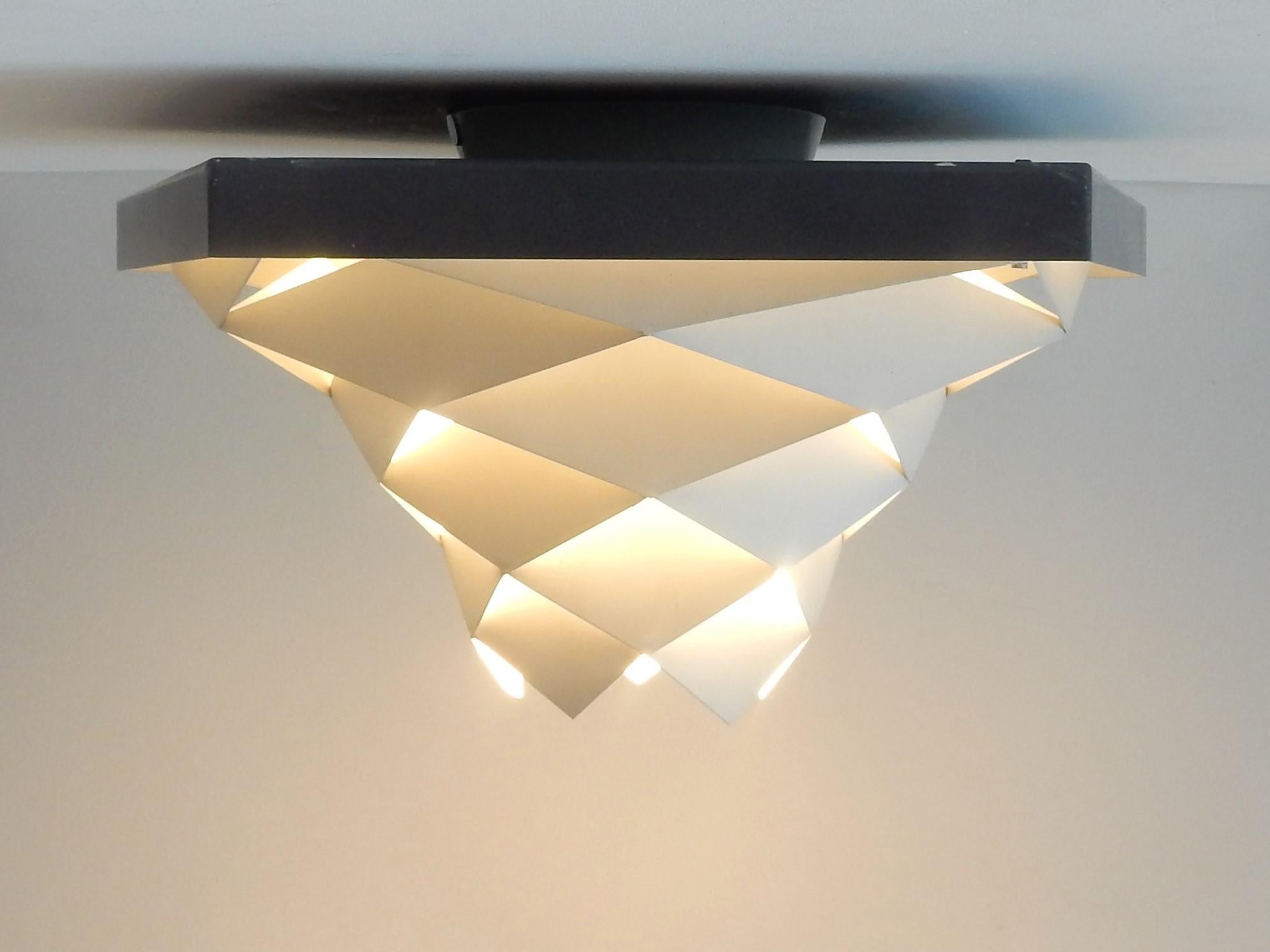 This decorative flushmount is a modernist and quite rare design by Preben Dahl for Hans Følsgaard. A design from the early 1960s, made of white and dark grey steel elements. The shape of this lamp gives a fantastic light, a true eye-catcher! We have