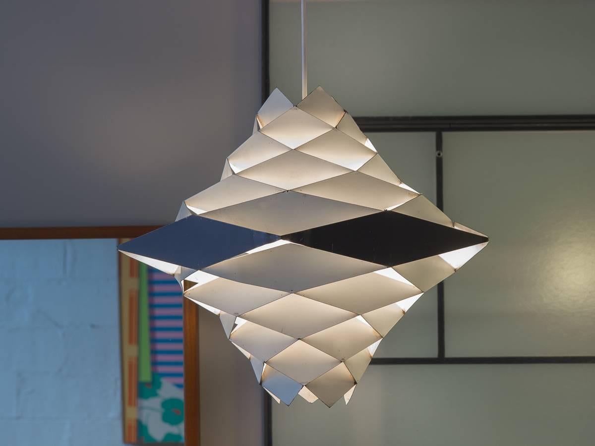 Lampe à suspension Symfoni opaque conçue par Preben Dahl pour Hans Folsgaard. Cette spectaculaire lampe à suspension géométrique présente des anneaux de facettes rhomboïdes qui dévient et distribuent la lumière à l'intérieur. Notre exemplaire des