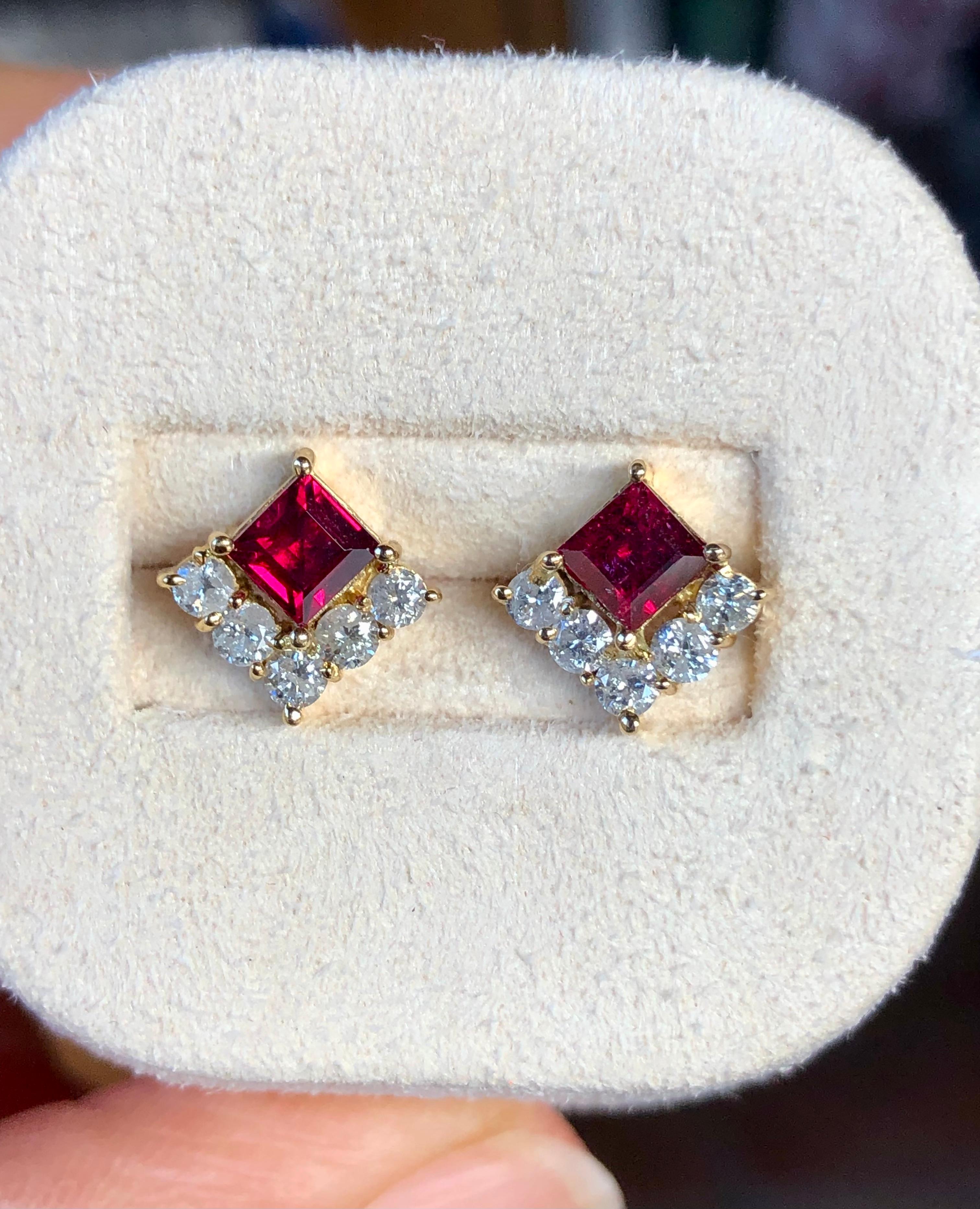 Un classico paio di orecchini a perno che sfoggiano vibranti rubini rossi a taglio quadrato, circondati su due lati da una fila di diamanti tondi brillanti in un design mozzafiato. I rubini pesano complessivamente 1,20 carati, i diamanti 0,60