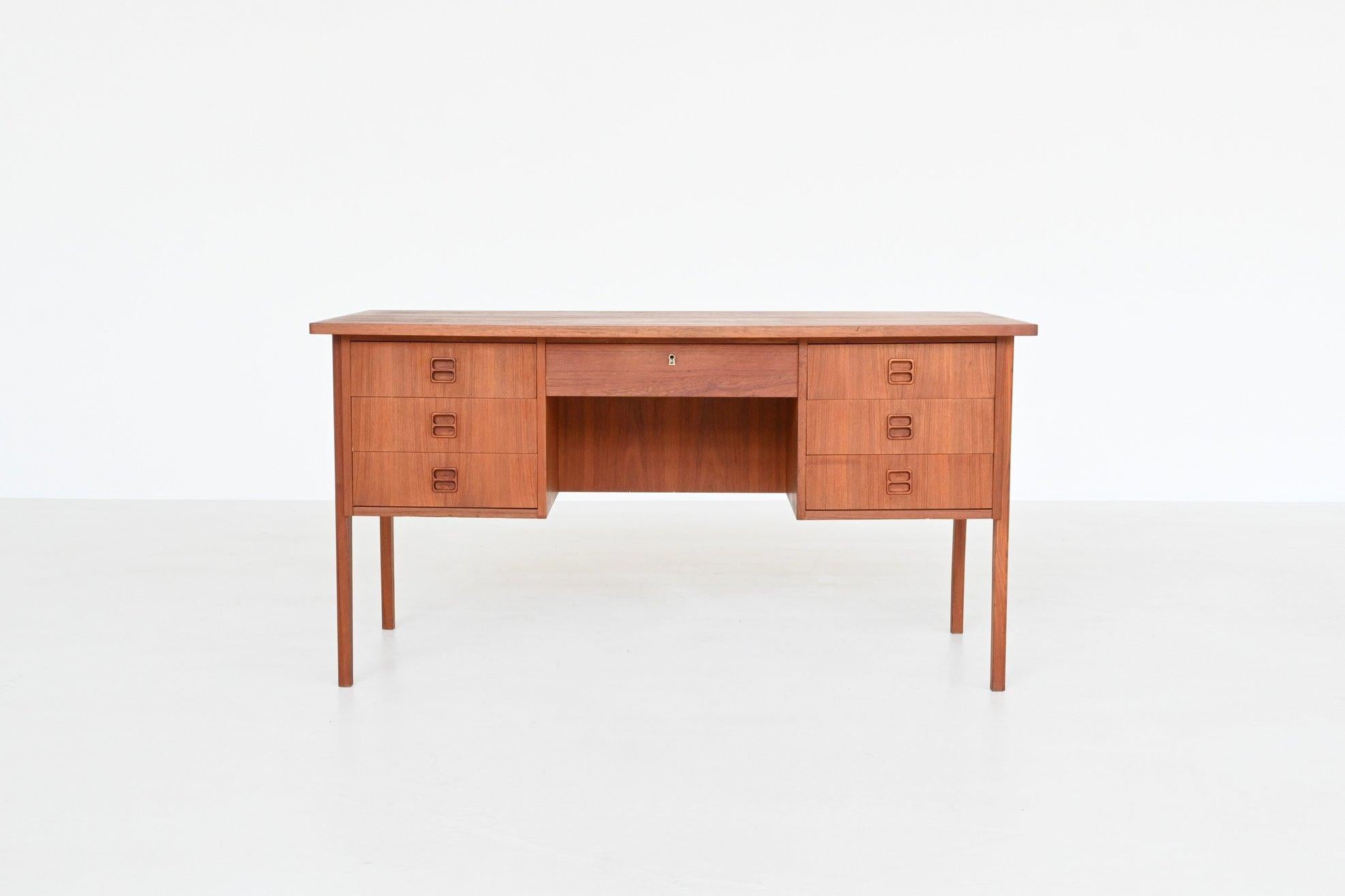 Beautiful symmetric shaped desk by unknown designer or manufacturer, Denmark 1960. It has functional storage space with three deep drawers on each side, one drawer in the middle between the drawer units and a shelf at the back. This well-crafted