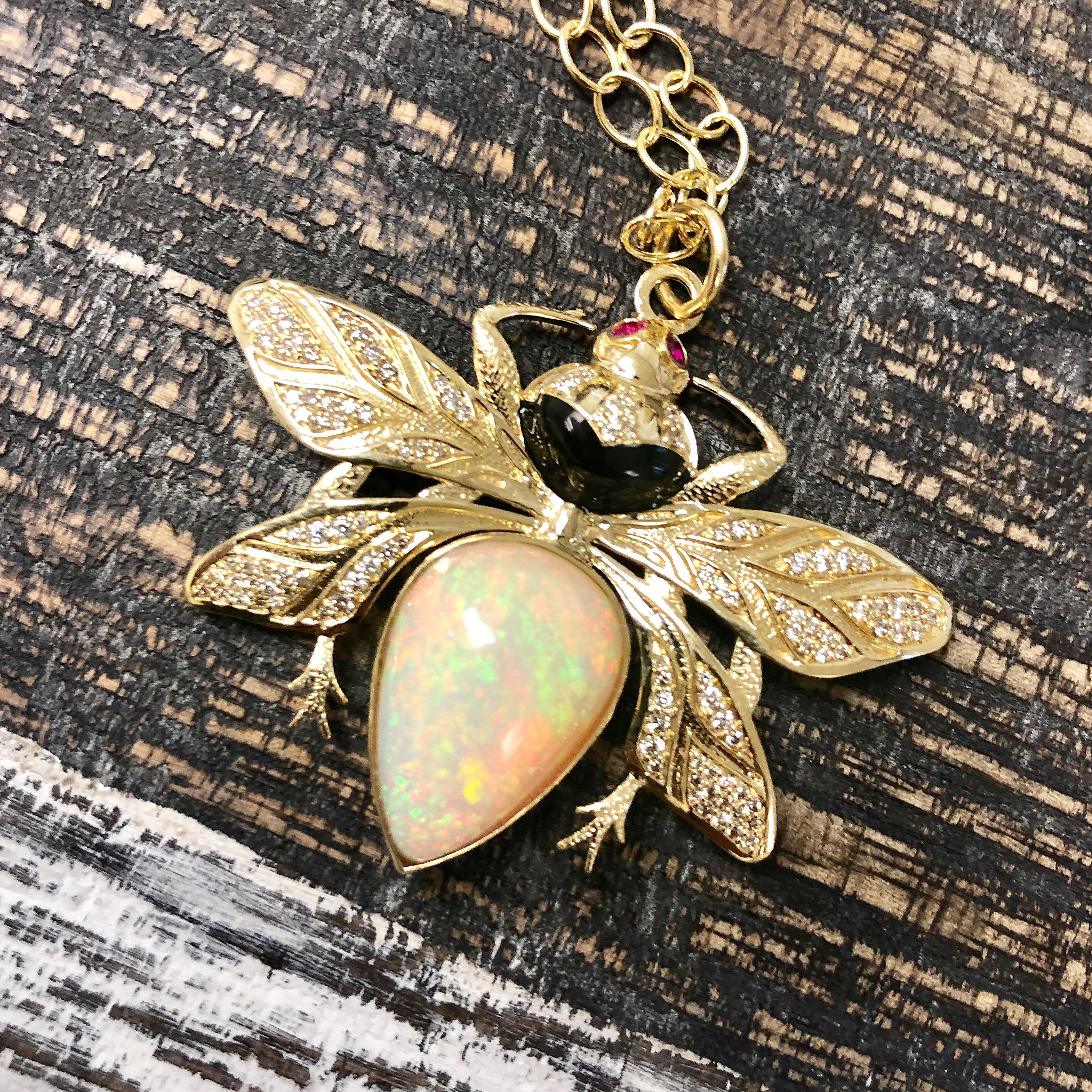 Created in 18 karat yellow gold 
One of a kind gorgeous Ethiopian opal 10 cts approx
Bright diamonds 0.50 ct approx
High intensity ruby cabochon eyes 0.10 ct approx
Intricate diamond setting in gold wings & feelers
Black enamel body details
One of a