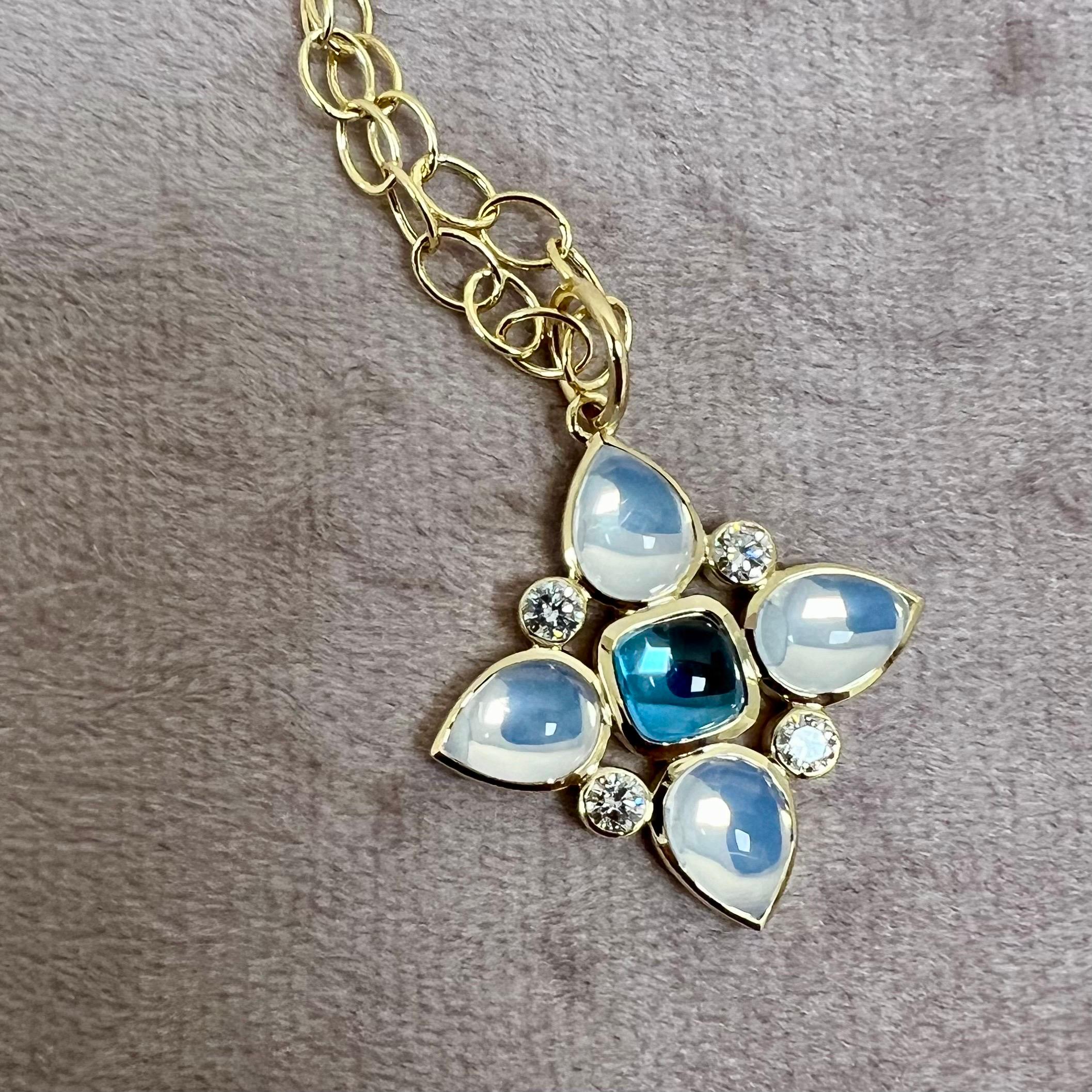 Created in 18 karat yellow gold
London Blue Topaz 1.50 carats approx.
Moon Quartz 4.50 carats approx.
Diamonds 0.45 carat approx.
Chain sold separately

Enrobing 18 karat yellow gold, a labradorite of 1.50 carats, moon quartz of 4.50 carats, and