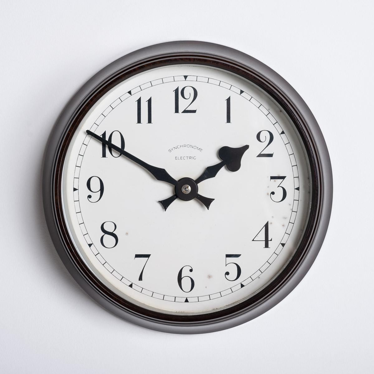 PETITE HORLOGE MURALE EN BAKÉLITE DE SYNCHRONOME

Une superbe petite horloge industrielle fabriquée en Angleterre vers 1940 par Synchronome.

Synchronome était le principal fabricant d'horloges au début et au milieu du 20e siècle, produisant