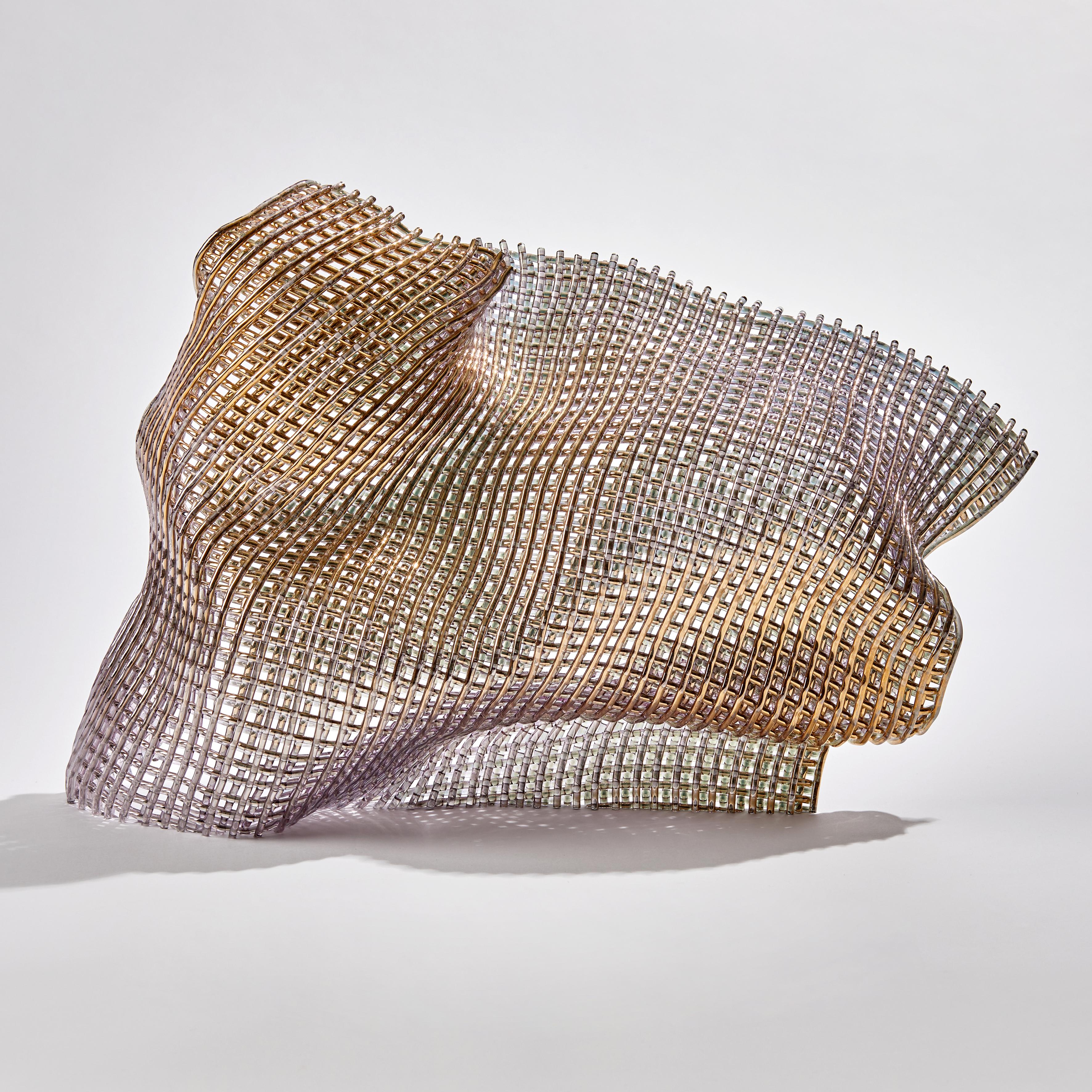 Synchronous I, is a unique gold and glass sculpture by the British artist Cathryn Shilling. Using her signature woven glass 'fabric' technique, Shilling layers kiln formed glass cane to create this beautiful latticed artwork, which has been finished