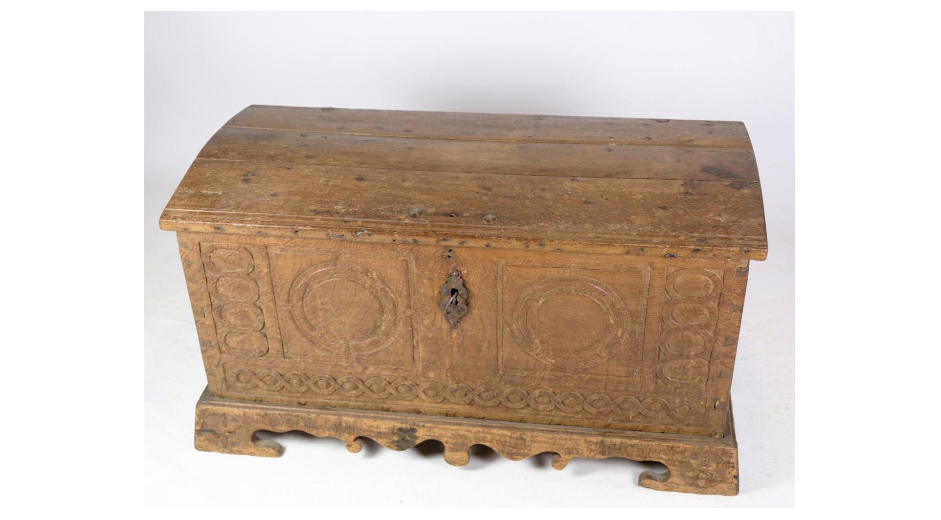 The Sønderjysk oak coffin with carvings from around the 1760s is a rare and extraordinary artifact that offers a glimpse into the funerary customs of the past. Crafted from solid oak, this coffin exhibits exceptional craftsmanship and attention to