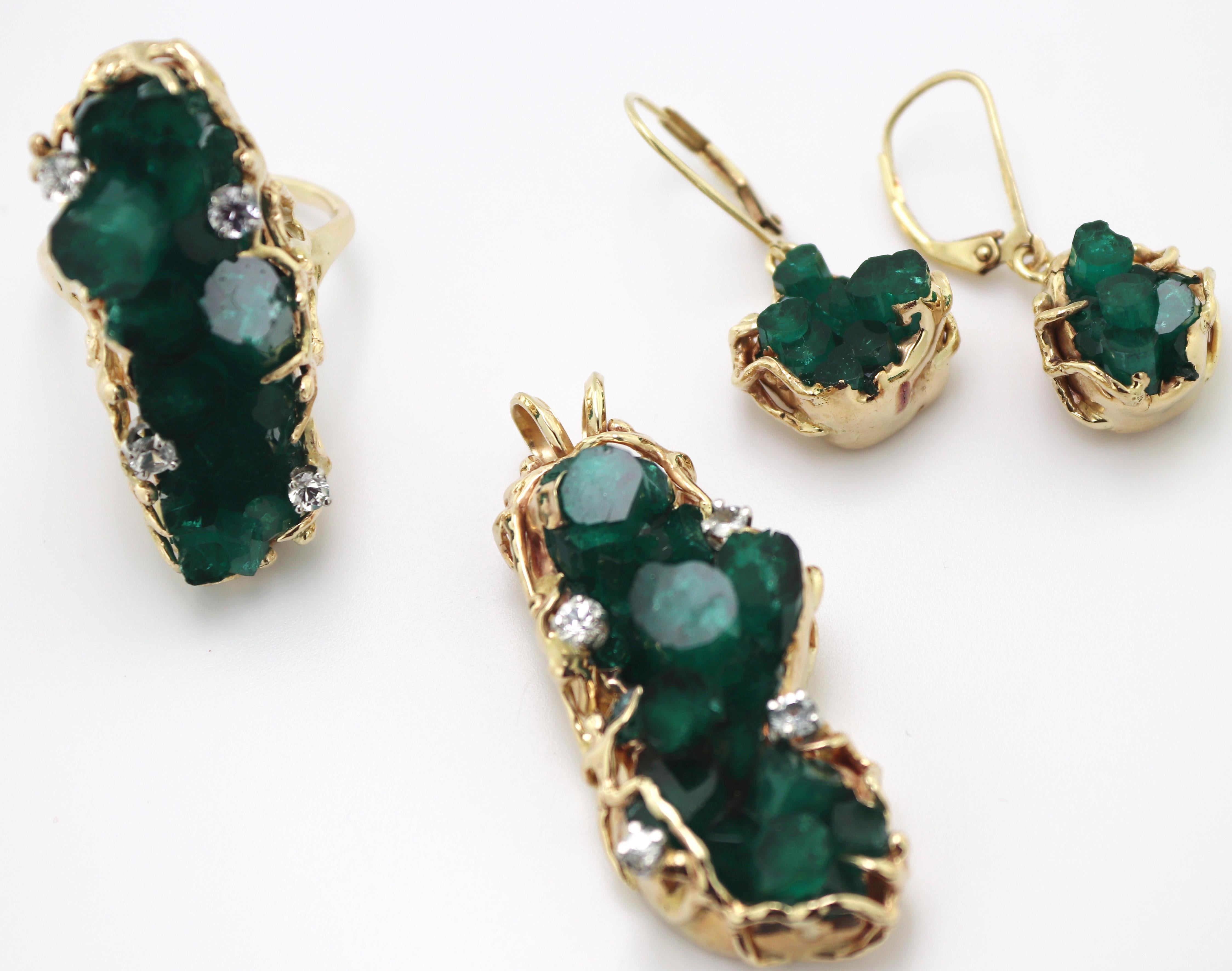 Including one ring; featuring one large cluster of 12 hexagonal synthetic
emerald crystals of bright deep green color, 34.1 X 11.5 X 9.0 mm,
accented by (4) round-cut white sapphires, set in a 14k yellow gold
freeform mounting, consisting of