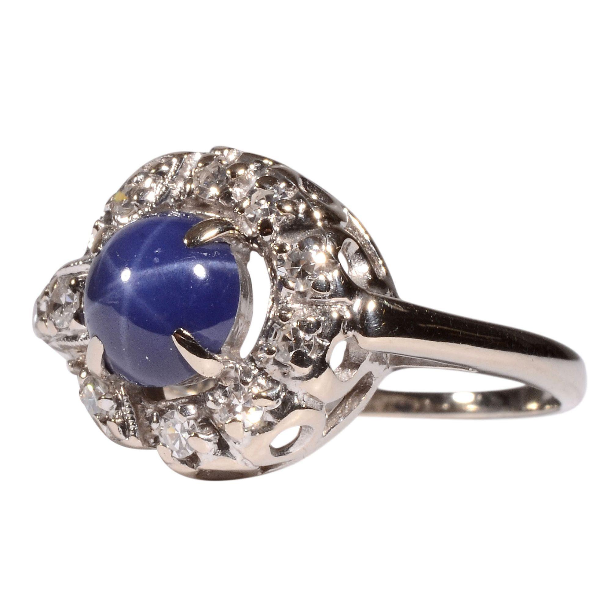 Estate synthetic star sapphire & diamond ring. This 14 karat white gold ring features a synthetic star sapphire accented with 10 single cut diamonds at .16 carat total weight. The diamonds have VS2 clarity and G-I color. This estate ring is a size