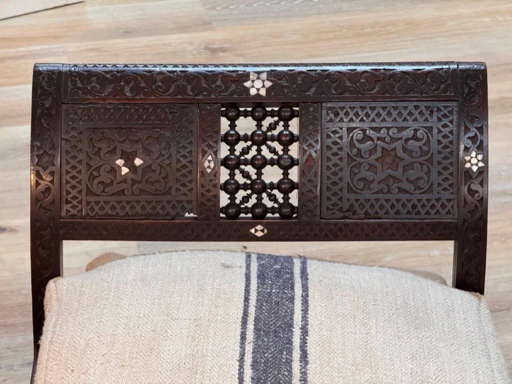 Syrian mother of pearl inlaid wooden bench having  intricately carved wood is inlaid with geometric stars of mother of pearl.  The arms and skirts are paneled with latticework.  There are some losses, but the overall look is excellent. Having a