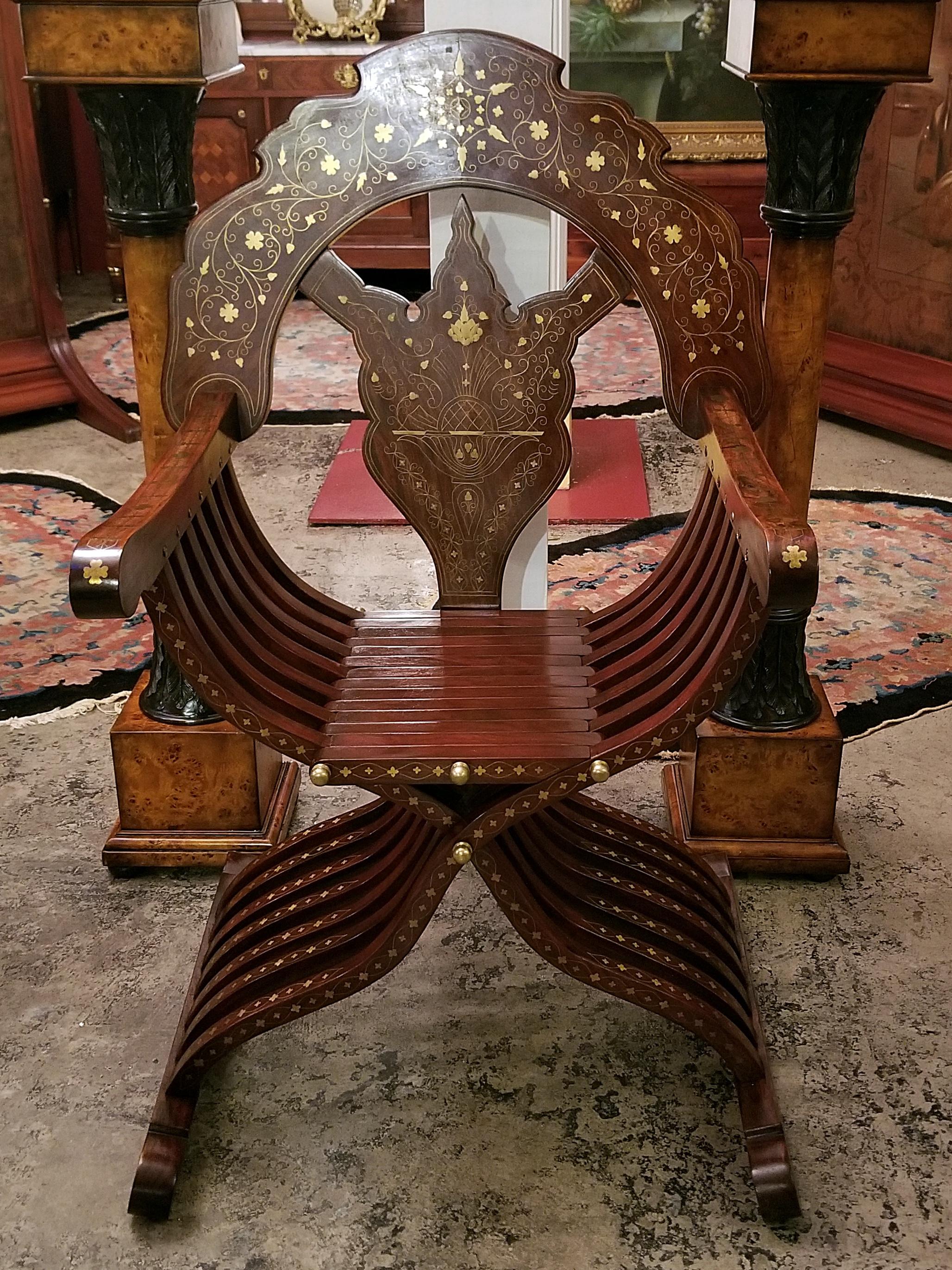 PRESENTING a GORGEOUS Middle Eastern Brass Inlaid Savonarola Chair.

20th Century, probably circa 1960-1980.

Teak inlaid with brass in floral and geometric patterns.

Probably made in Pakistan or one of the Middle Eastern countries … a region