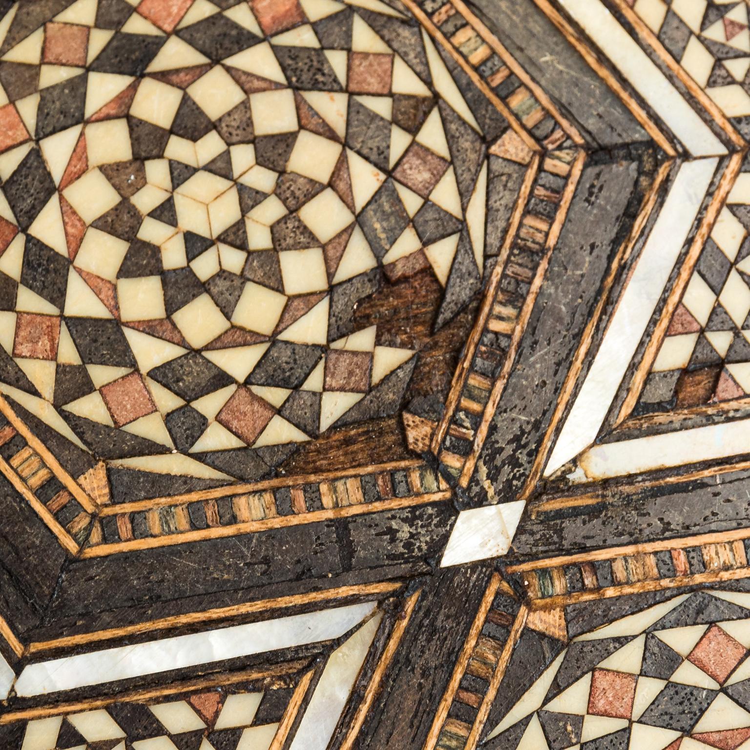 Circular side table from Syria with mother of pearl geometric inlay and bottom shelf, circa 1960s. Please note of minor losses due to wear with age.