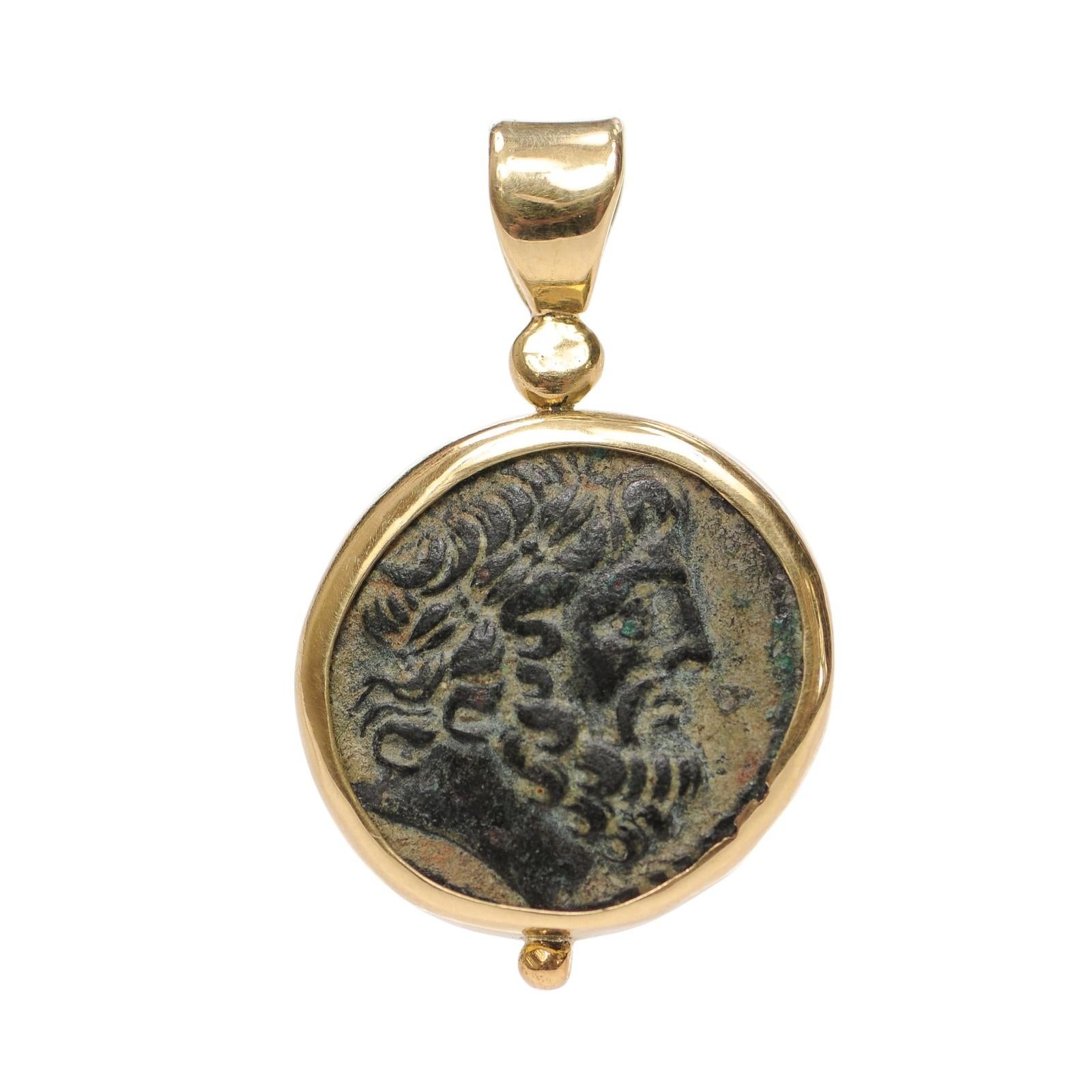 Una superba moneta della Siria, Seleukia e Pieria, Apameo, del 70 a.C., rifinita con oro a 18 carati come un pendente. Sul dritto, la testa laureata di Zeus rivolta a destra, con una splendida macchia di verderame naturale all'altezza dell'occhio.