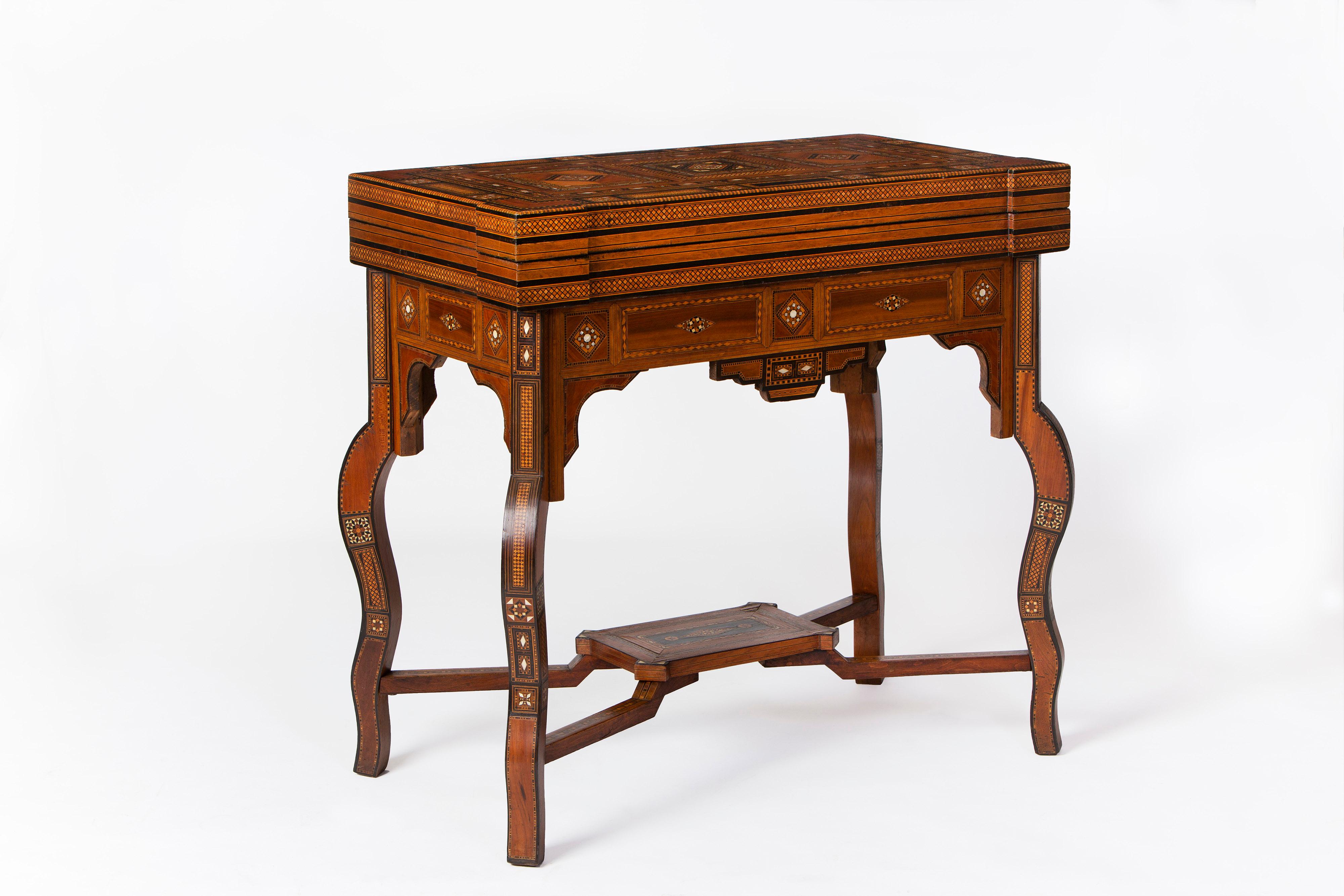 Exceptional Syrian games table, late 19th century sitting on cabriole shaped legs, united by a stepped stretcher which has a central shelf, and all decorated with a profusion of inlayed exotic woods including ebony, Santos rosewood, kingwood,