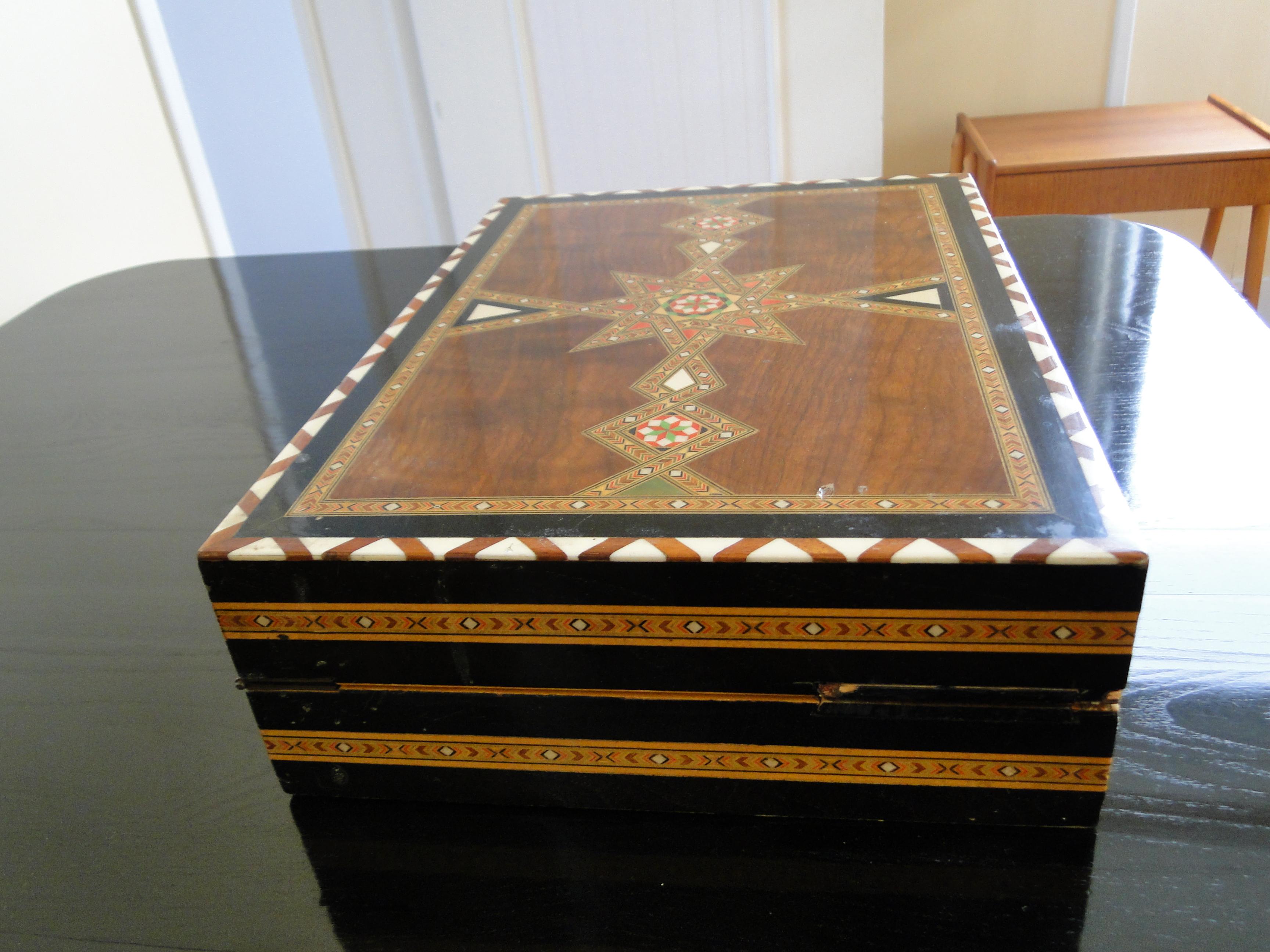 Stunning mosaic design and gorgeous craftsmanship. The board/ box is made of various wood, mother-of-pearl .
A genuine work of art.
All the pieces of the chess game are present and original.

4 compartments padded with red felt to store the