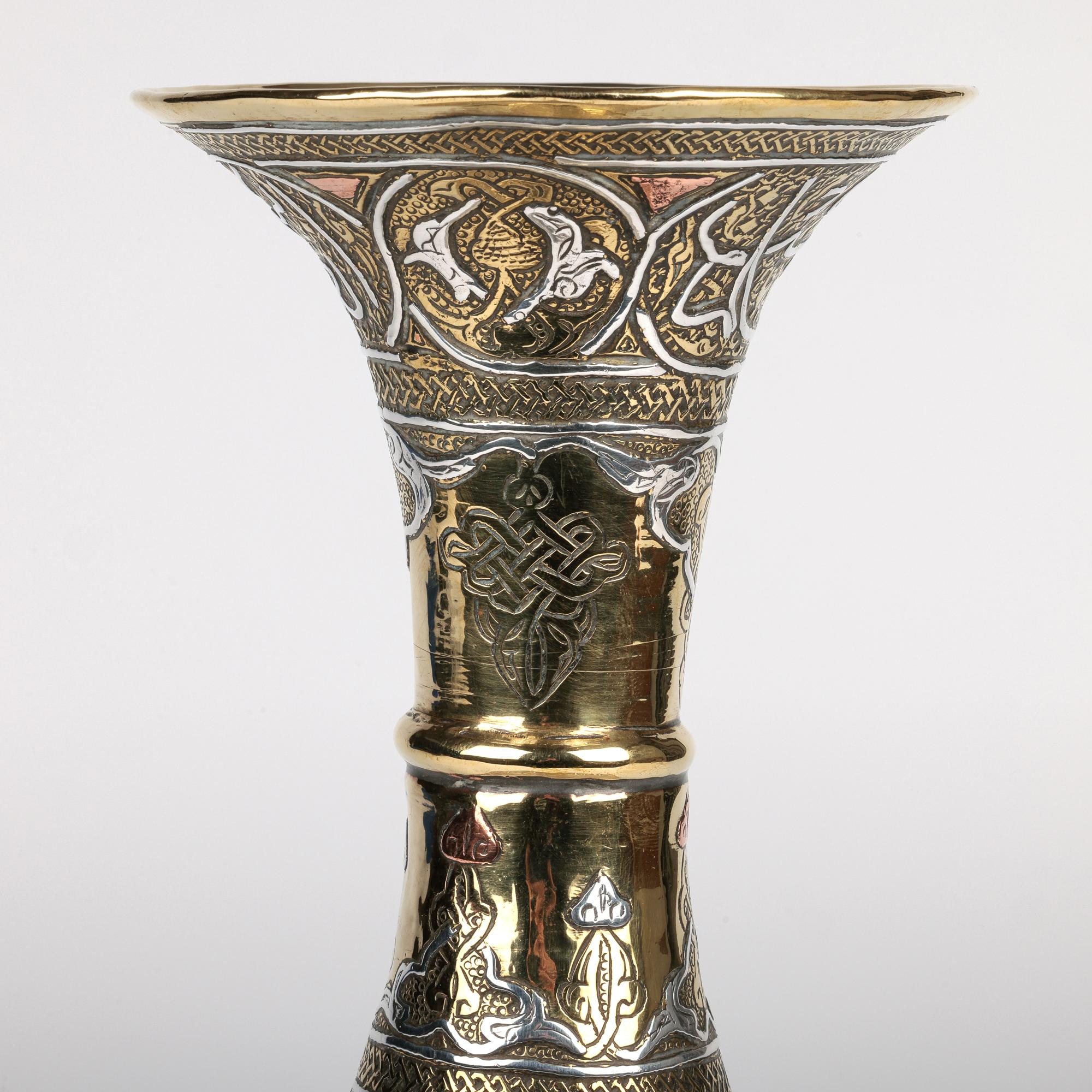 Vase en laiton de style Mamluke, incrusté d'argent et de cuivre, datant du début ou du milieu du 20e siècle. 

Le renouveau Mamluke est un mouvement culturel au cours duquel une grande partie du Moyen-Orient a cherché à préserver et à célébrer
