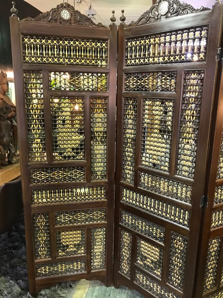 A special and rare piece. Hand carved and crafted by a master craftsman in heavy wood (likely teak) with beautifully designed patterns with interplay between dark and light wood pieces which created images within the spindled stick and ball windows.