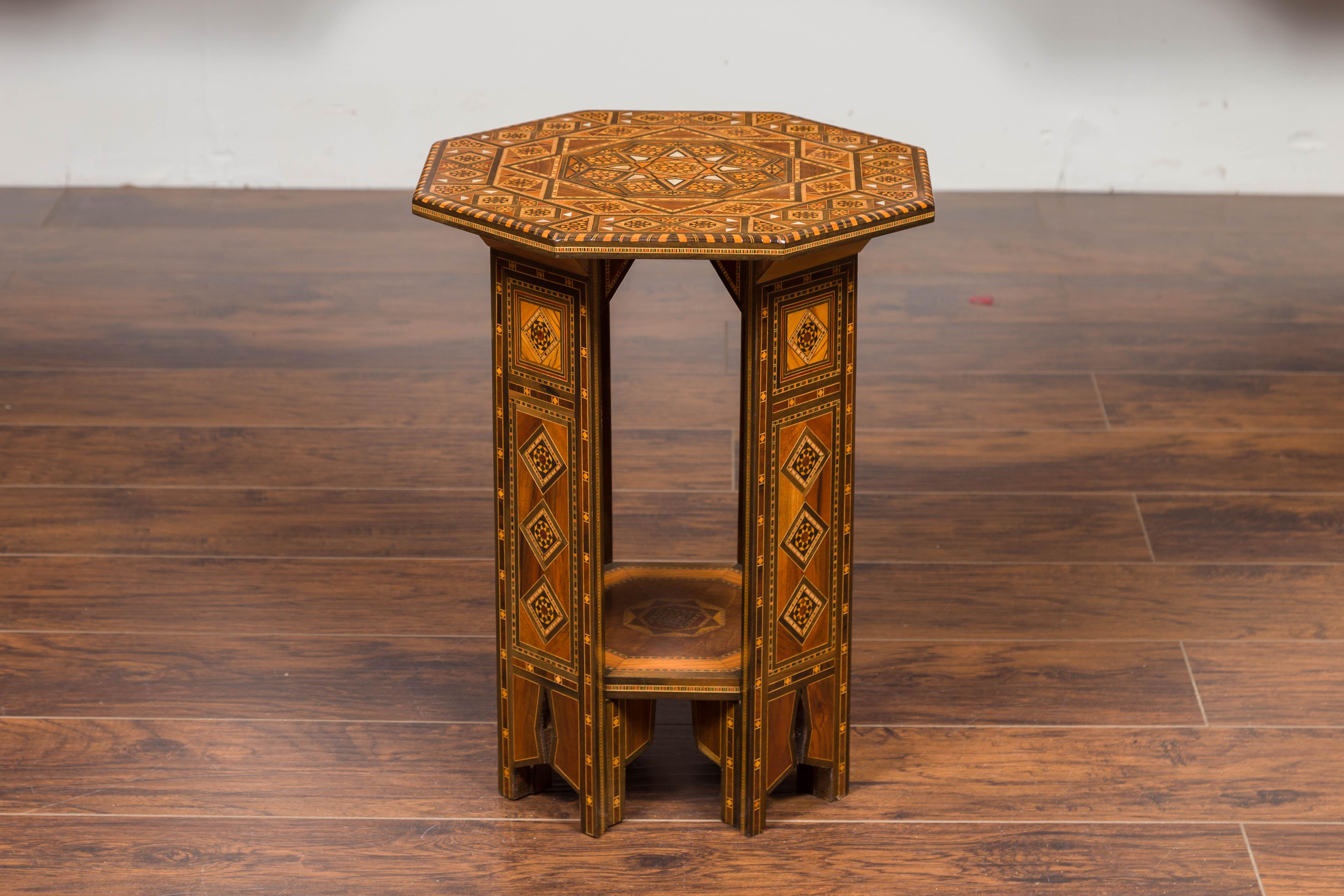 A Syrian octagonal Moorish style low side table from the first half of the 20th century with hand painted polychrome geometric decor and pierced canted sides. Capturing our attention with its elegant silhouette, this Moorish style side table
