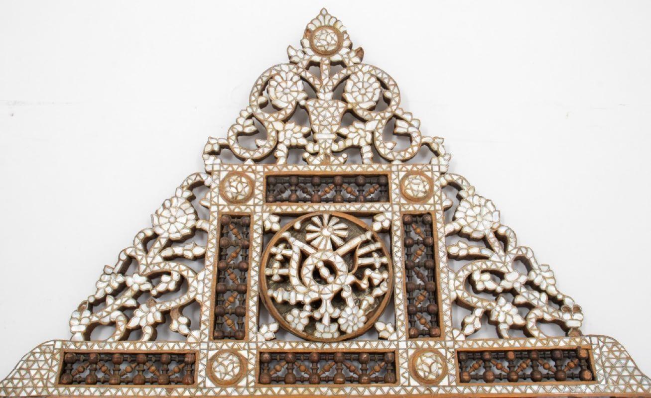 Syrian Mother of pearl inlaid fretwork mirror, of monumental scale, with elaborate reticulated cornice in floral designs, the sides and base similarly decorated, centering a beveled mirror plate surrounded by etched bone and rosewood fretwork.  The