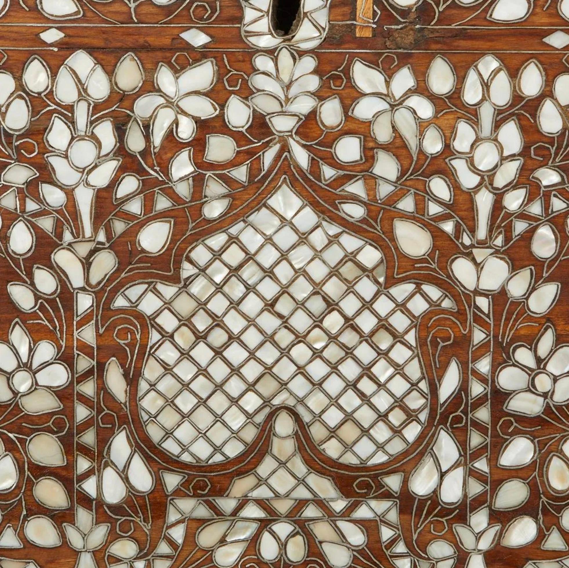 Syrian mother of pearl inlaid wooden wedding or dowry chest. The trunk is profusely inlaid with intricate geometric and floral designs in mother of pearl with the intarsia method. The lid lifts to reveal two small compartments within a larger