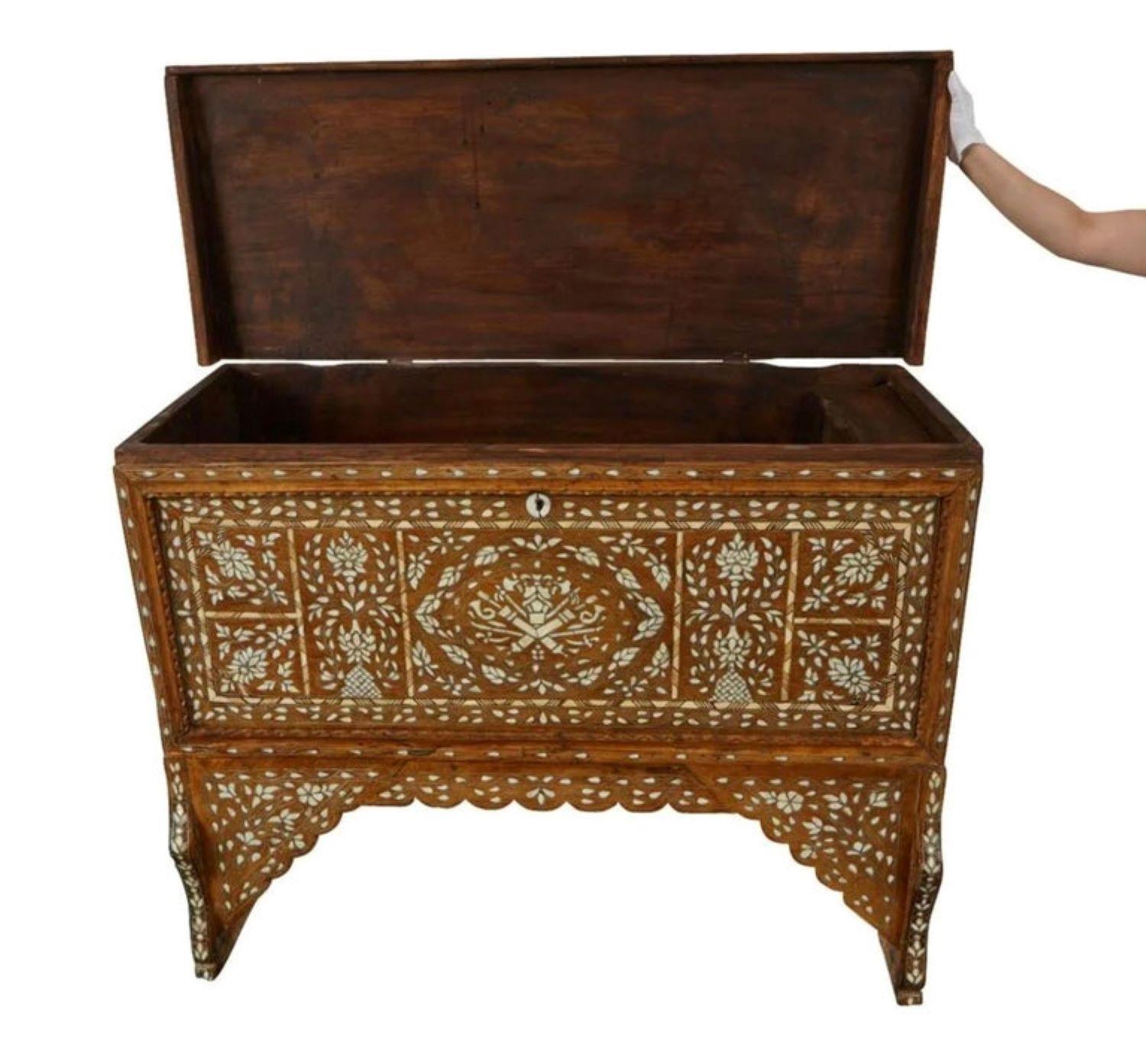 Syrian mother of pearl inlaid wooden wedding or dowry chest. The trunk is profusely inlaid with intricate geometric and floral designs in mother of pearl with the intarsia method. The lid lifts to reveal two small compartments within a larger