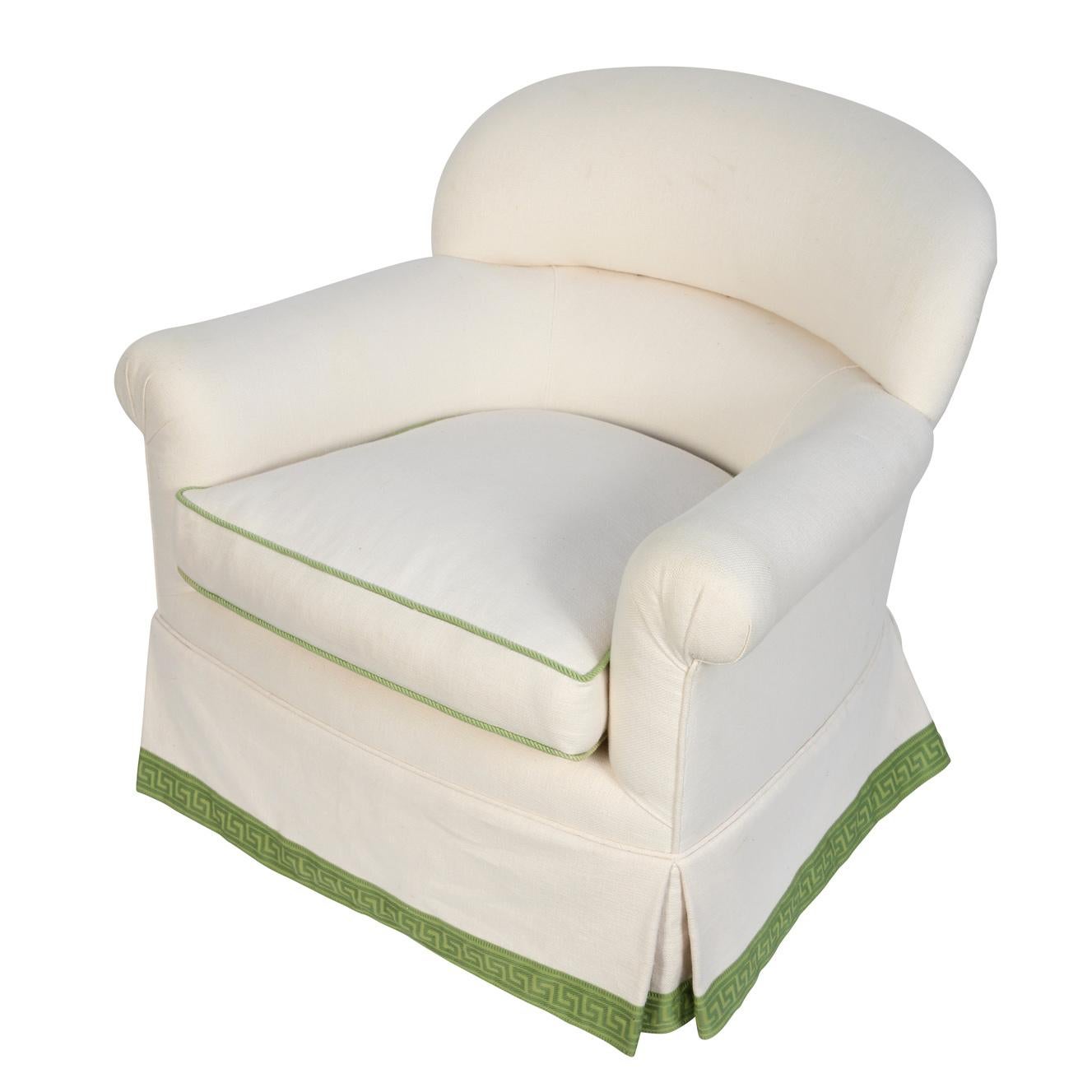 Syrie Maugham upholstered arm chair with curved back, newly upholstered in white linen with green detail.