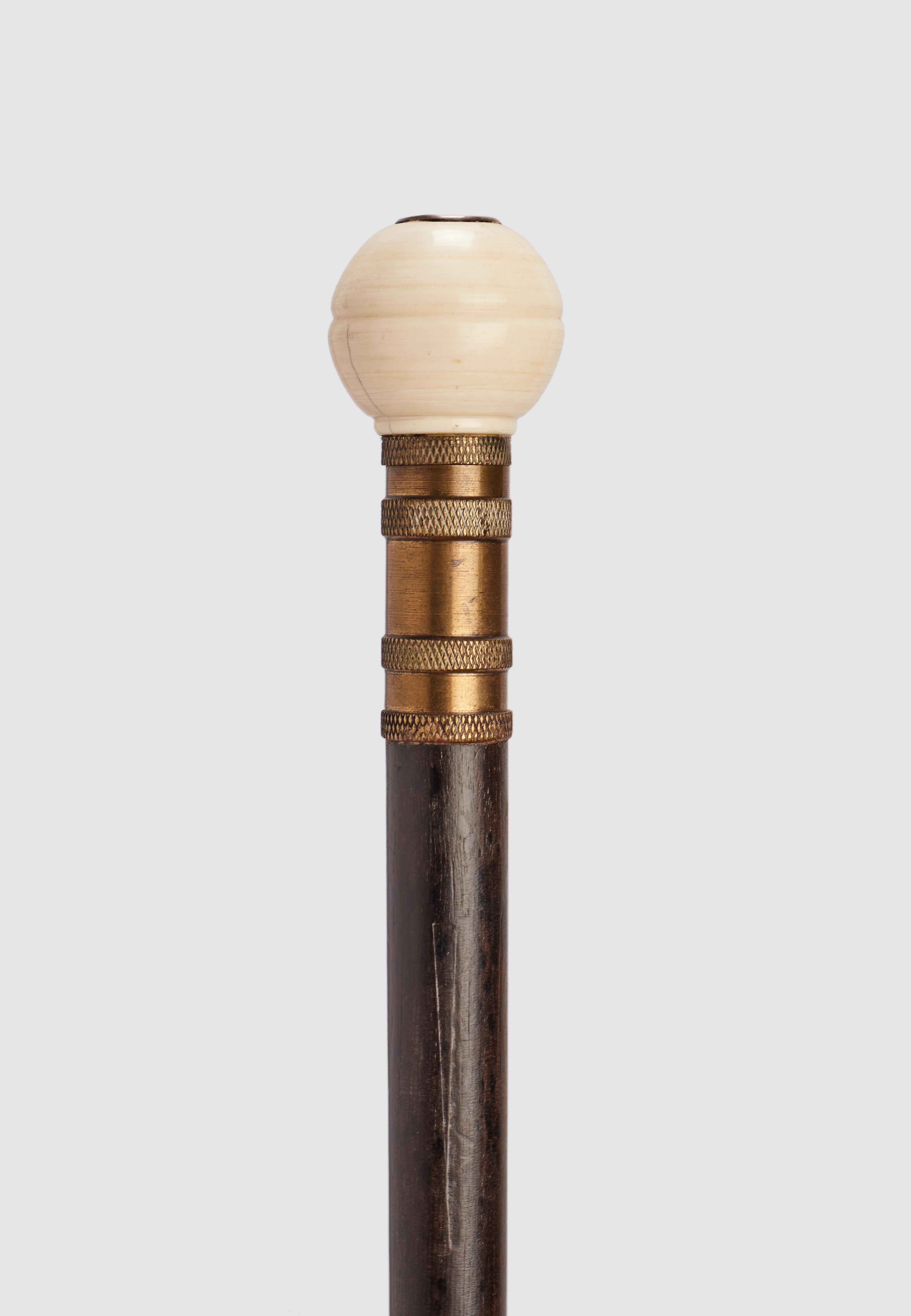Gadget System Stick: Stick mit Feuerzeugfunktion. Korpus aus Ebenholz, Knauf aus Elfenbein mit reliefiertem Monogramm aus Silber mit den Buchstaben N und H, Metallzwinge. Durch Abschrauben des Knopfes kommt ein Feuerzeug zum Vorschein. Frankreich um