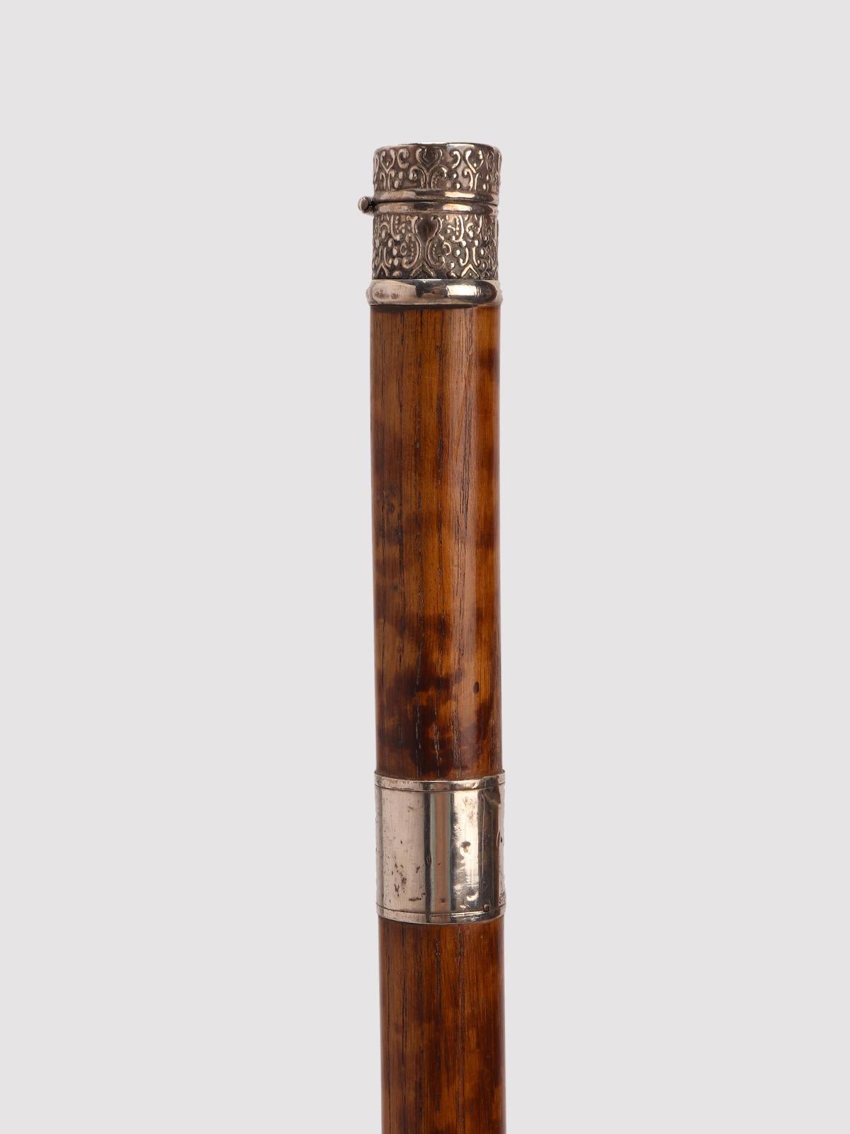 System walking stick, flamed fruit wood barrel, with 925/1000 sterling silver knob and band, acting as a container for a sewing thimble. Brass tip. United States of America early 20th century.