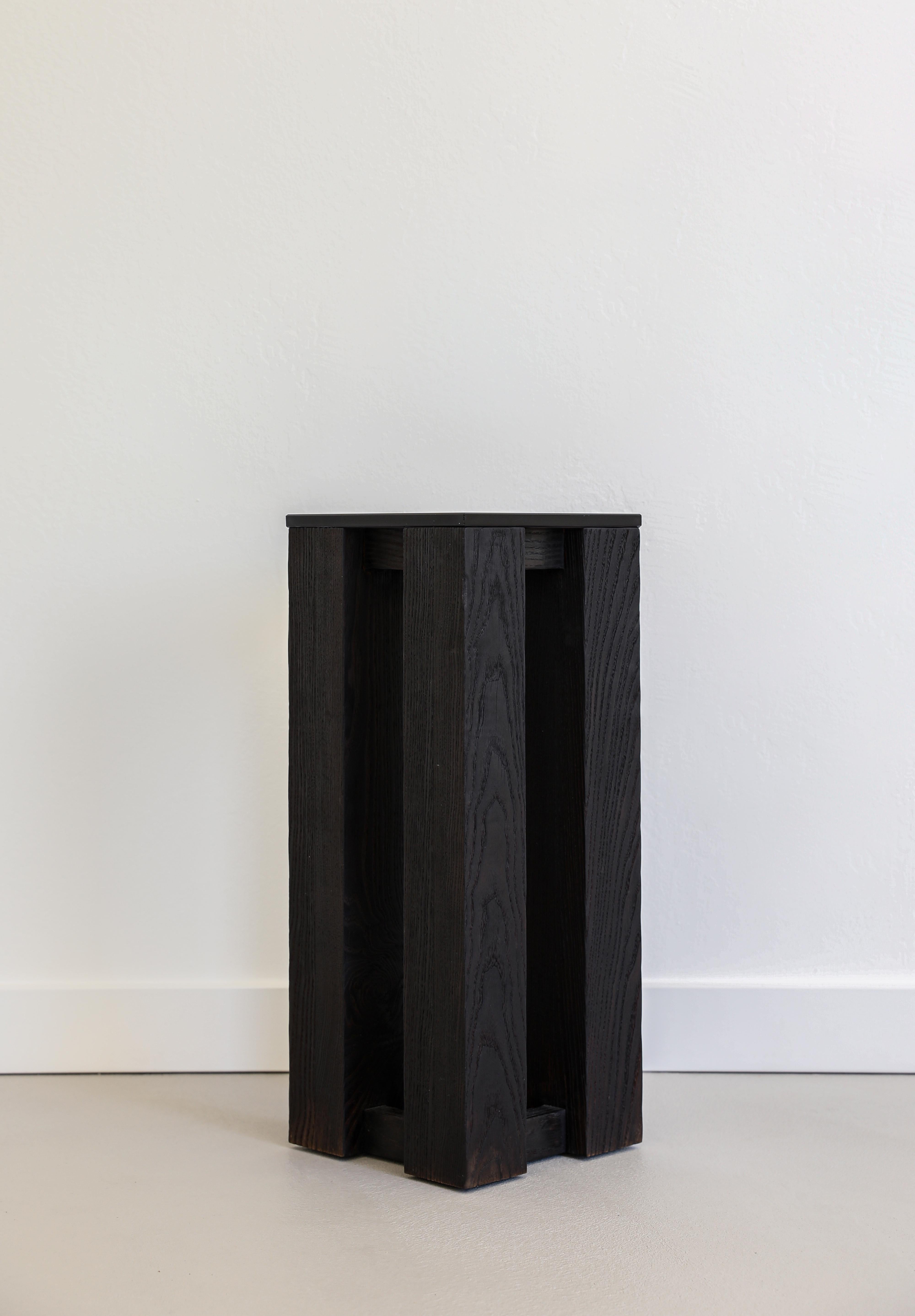 T-03 Side Table by Orlando Pippig
Dimensions: W 23 x D 23 x H 57 cm (Dimensions may vary slightly)
Materials: Burnt Ash

T-03 was designed to harness opposites: light and dark, solid and void, an exercise in juxtaposition.

Inspired by the framework