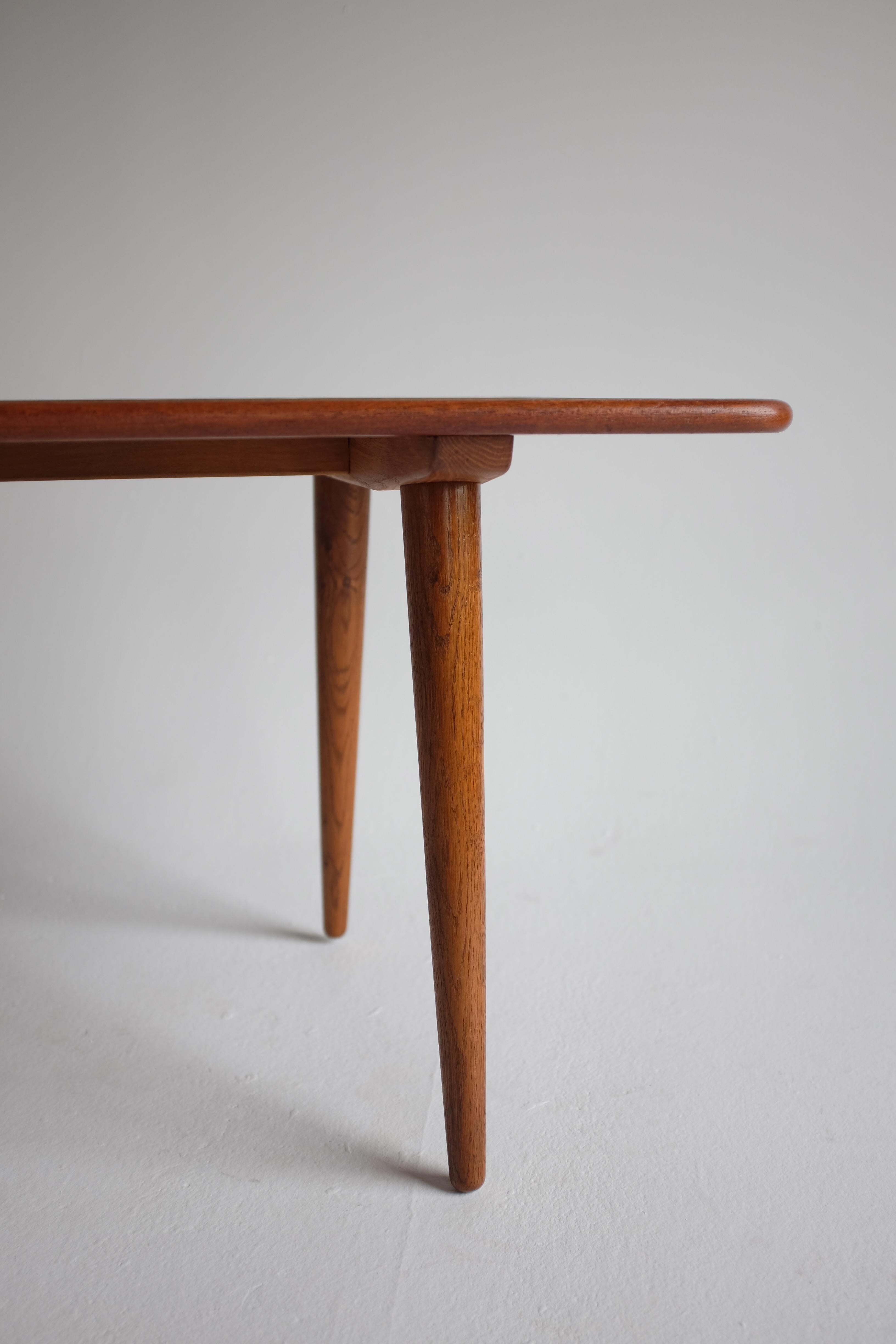 Ikonischer Couchtisch T-11 von Hans Wegner für Andreas Tuck, Dänemark. Dieses Stück hat eine Platte aus Teakholz mit Beinen aus Eichenholz und ist darunter markiert. Der 1954 entworfene und in den 1950er Jahren hergestellte Stuhl ist ein klassisches