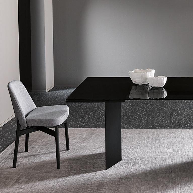La table haute modèle T-AB du designer Giulio Mancini a été conçue pour les salles à manger et les environnements décorés avec un style contemporain. La table a un plateau central fixe et des extensions latérales qui reposent sur des pieds en métal.