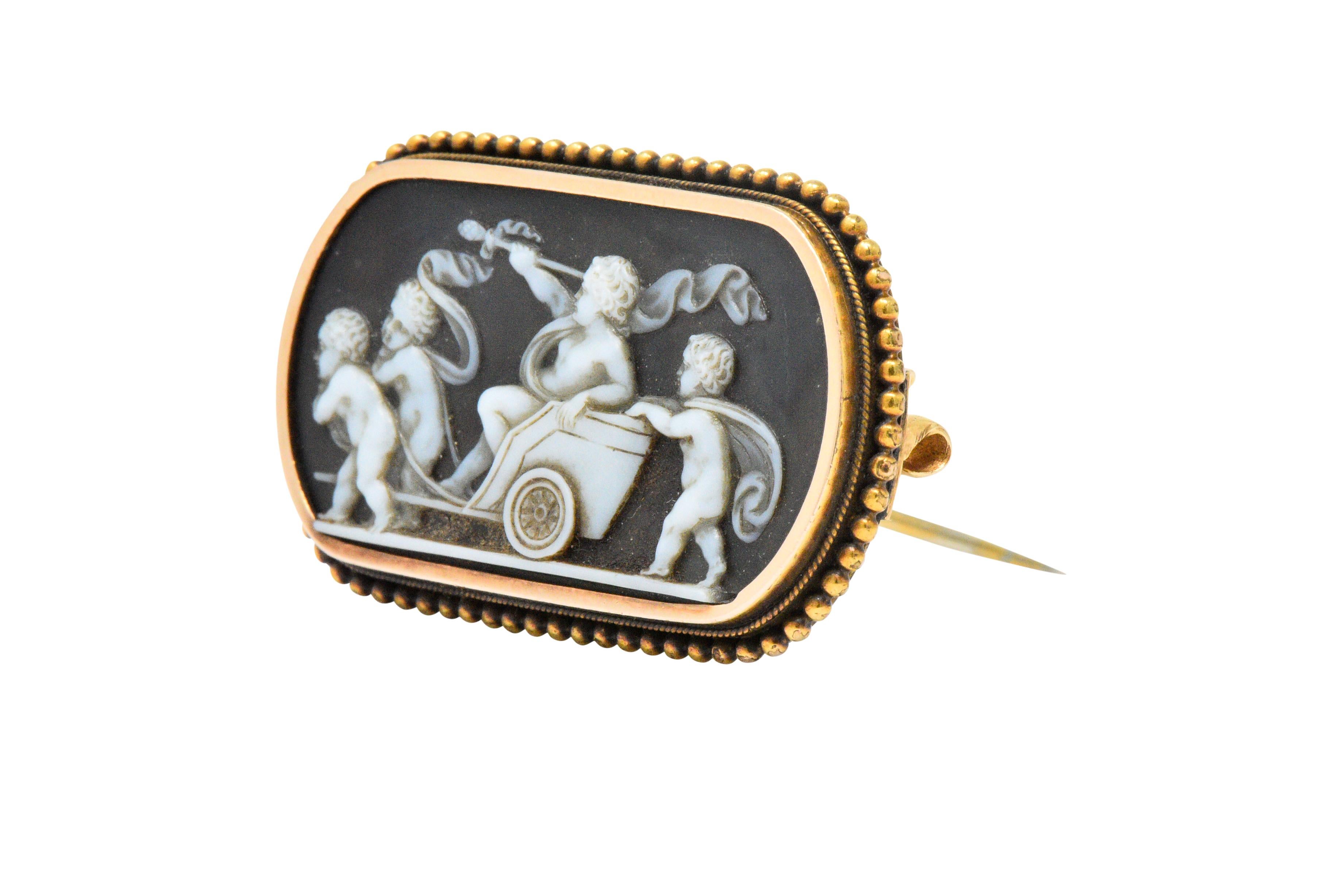 Carved onyx depicting putti pulling a chariot with a man has flowing garments and a staff

Exquisitely carved with attention to detail

Millegrain and rose gold beaded frame

Fully signed T.B. Starr

Measures: 1 3/8 x 7/8 Inches

Total Weight: 7.2