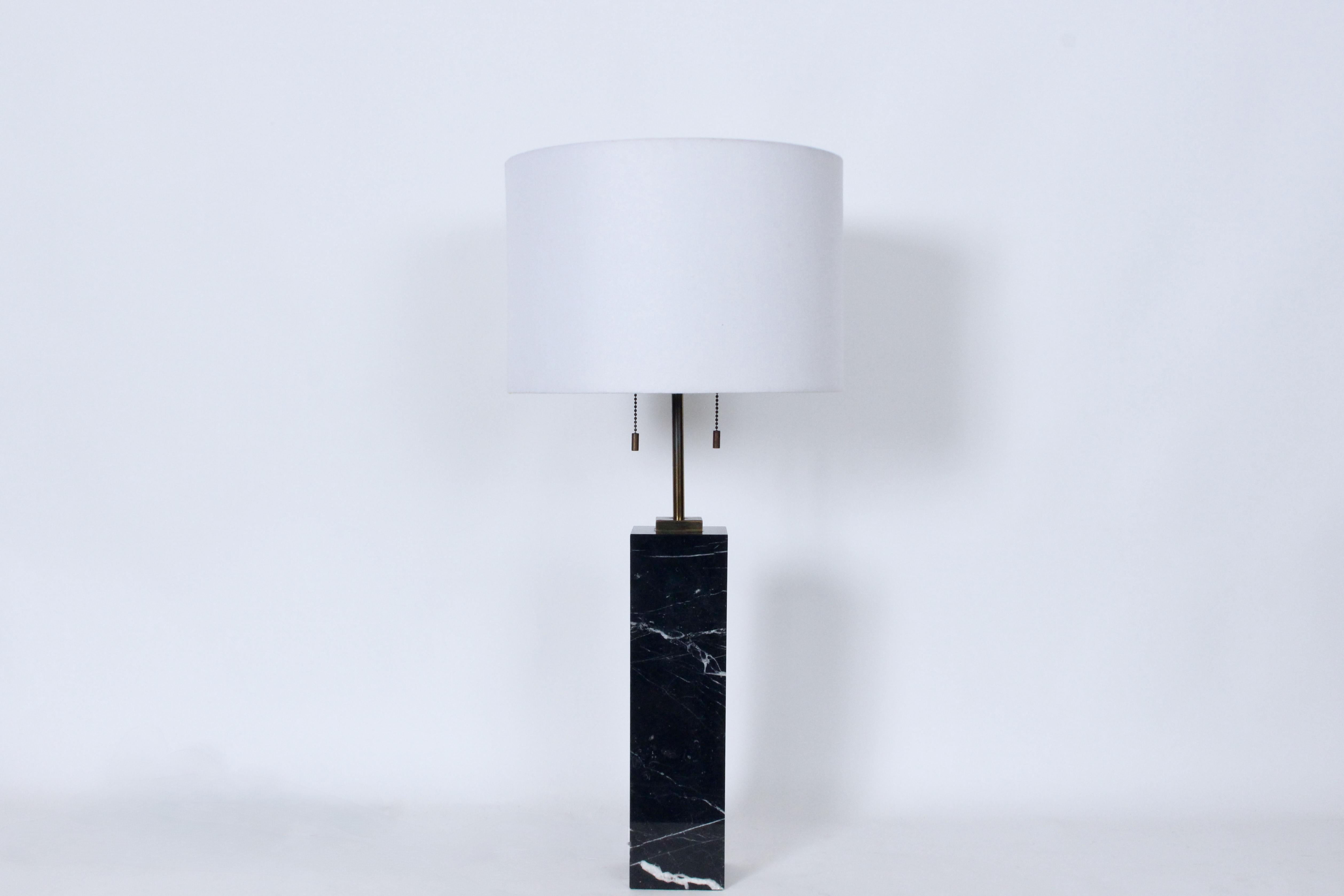 T. H. Robsjohn-Gibbings for Hansen Black Italian Marble Table Lamp.  Featuring a square block form in solid Black Marble, White veining throughout, detailed with a square (3W x 3D) plated Brass hardware, original adjustable double ball sockets