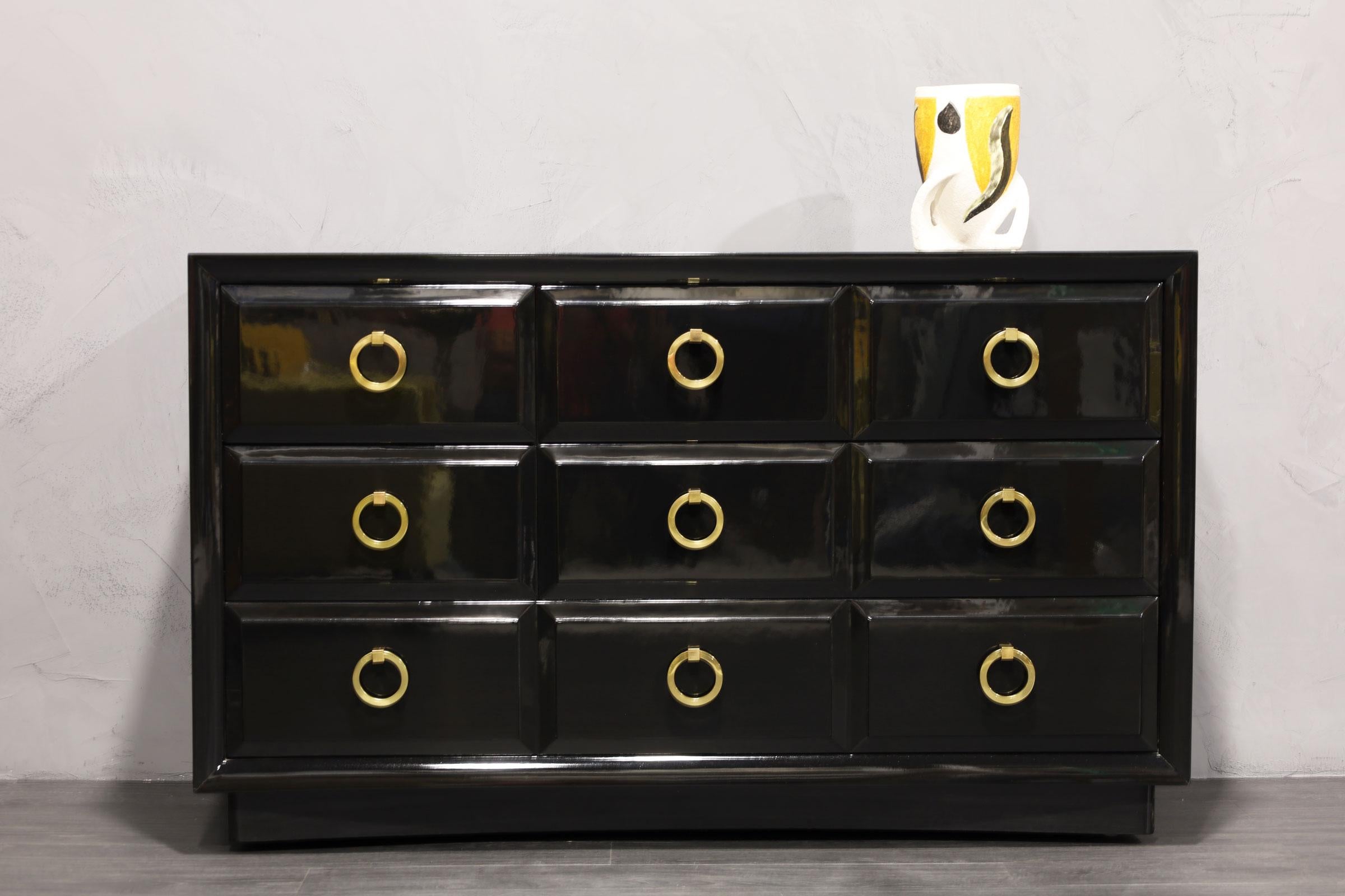 A beautifully restored cabinet by Robsjohn-Gibbings for Widdicomb. This is a classic and quite substantial. We have expertly black lacquered. Pulls are solid brass and have been polished and sealed.