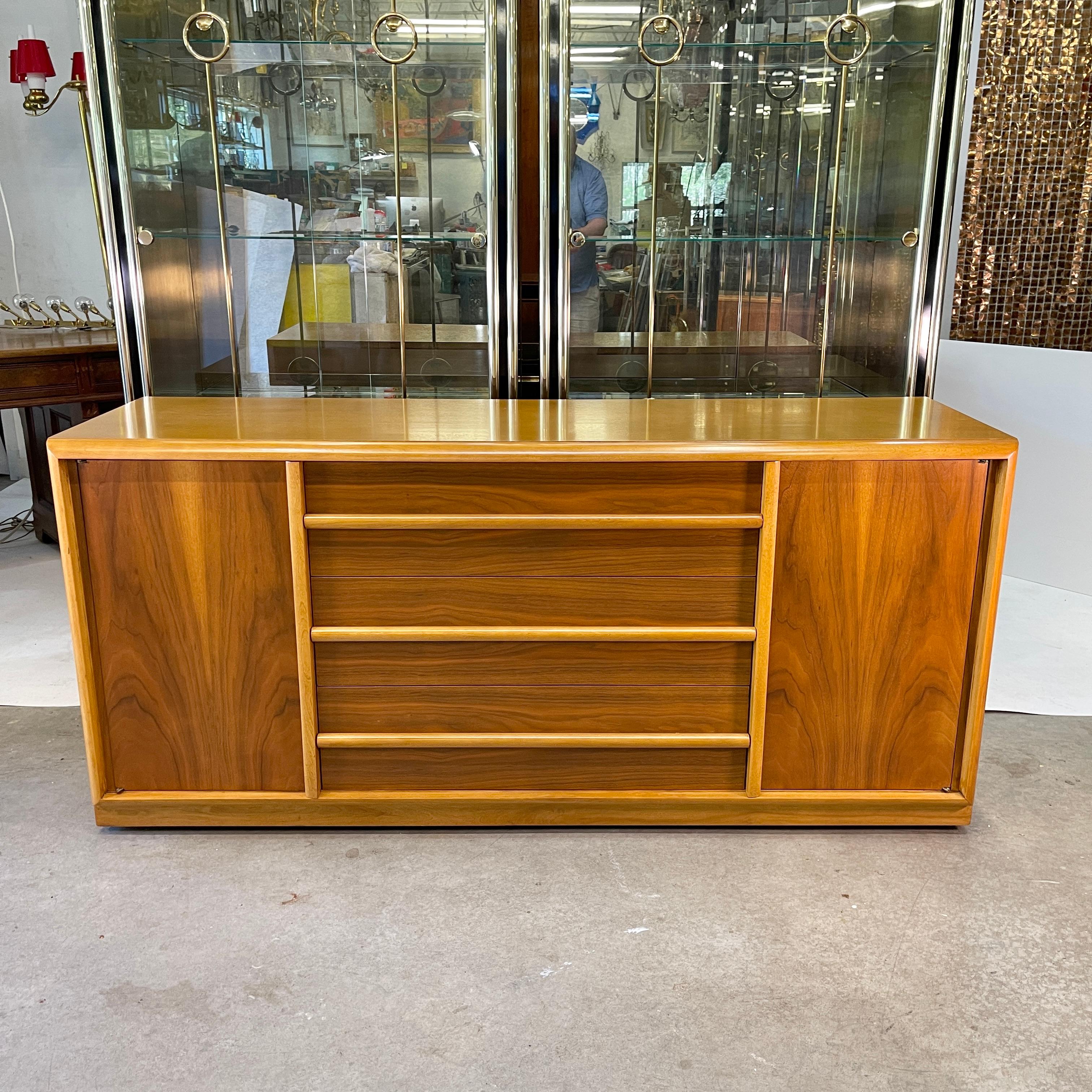 American classical modern buffet server cabinet designed by Robsjohn-Gibbings for Widdicomb Furniture Co. in figured walnut with contrasting maple moldings. Original label in top center drawer. Beautifully finished on all sides as well as inside.