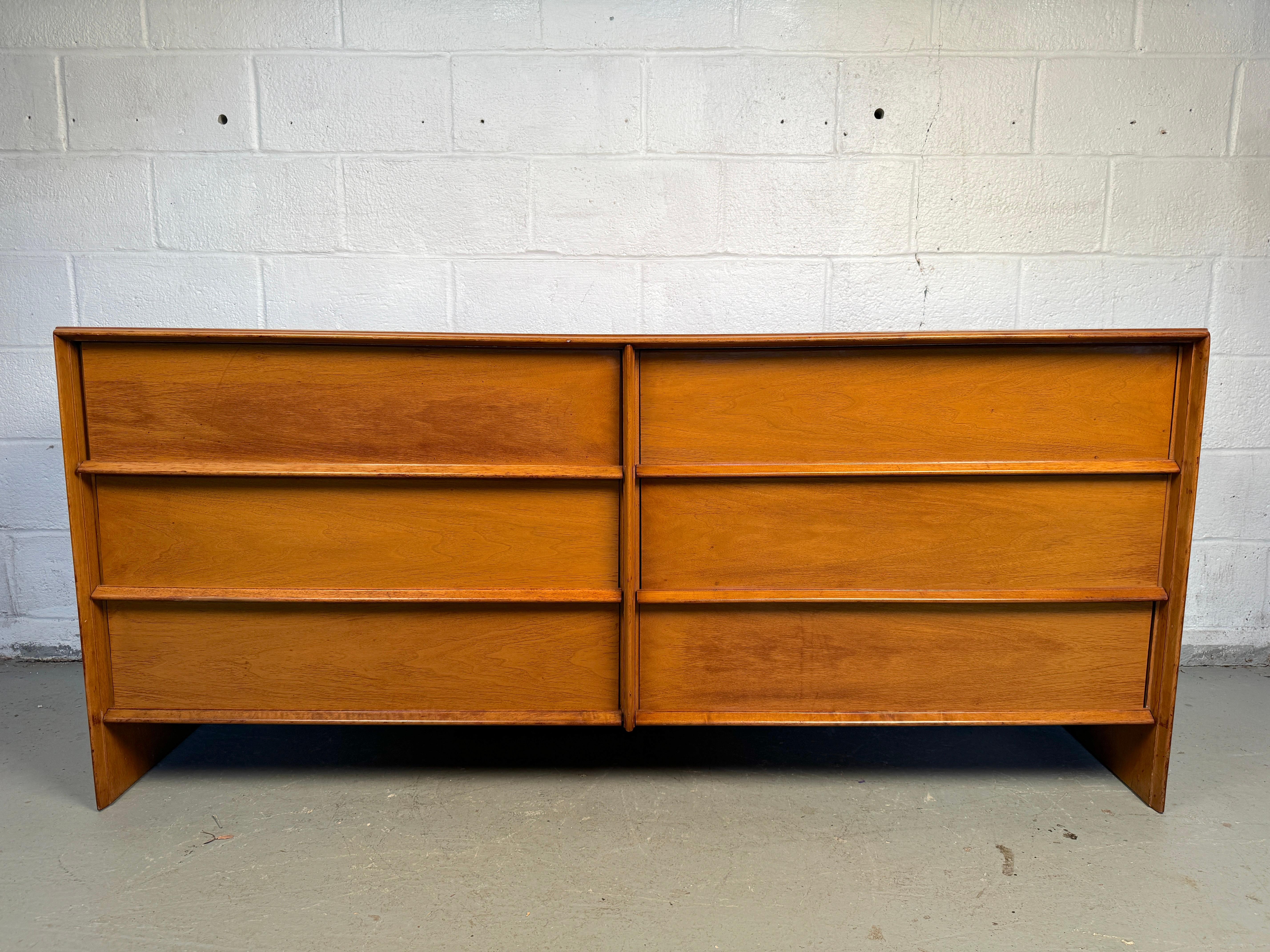 Questo elegante modello a sei cassetti di T.H. Il comò in noce Robsjohn-Gibbings for Widdicomb è un pezzo magistrale di design moderno di metà secolo. Realizzato in noce ricco e lucente, presenta una miscela armoniosa di forma e funzione con linee