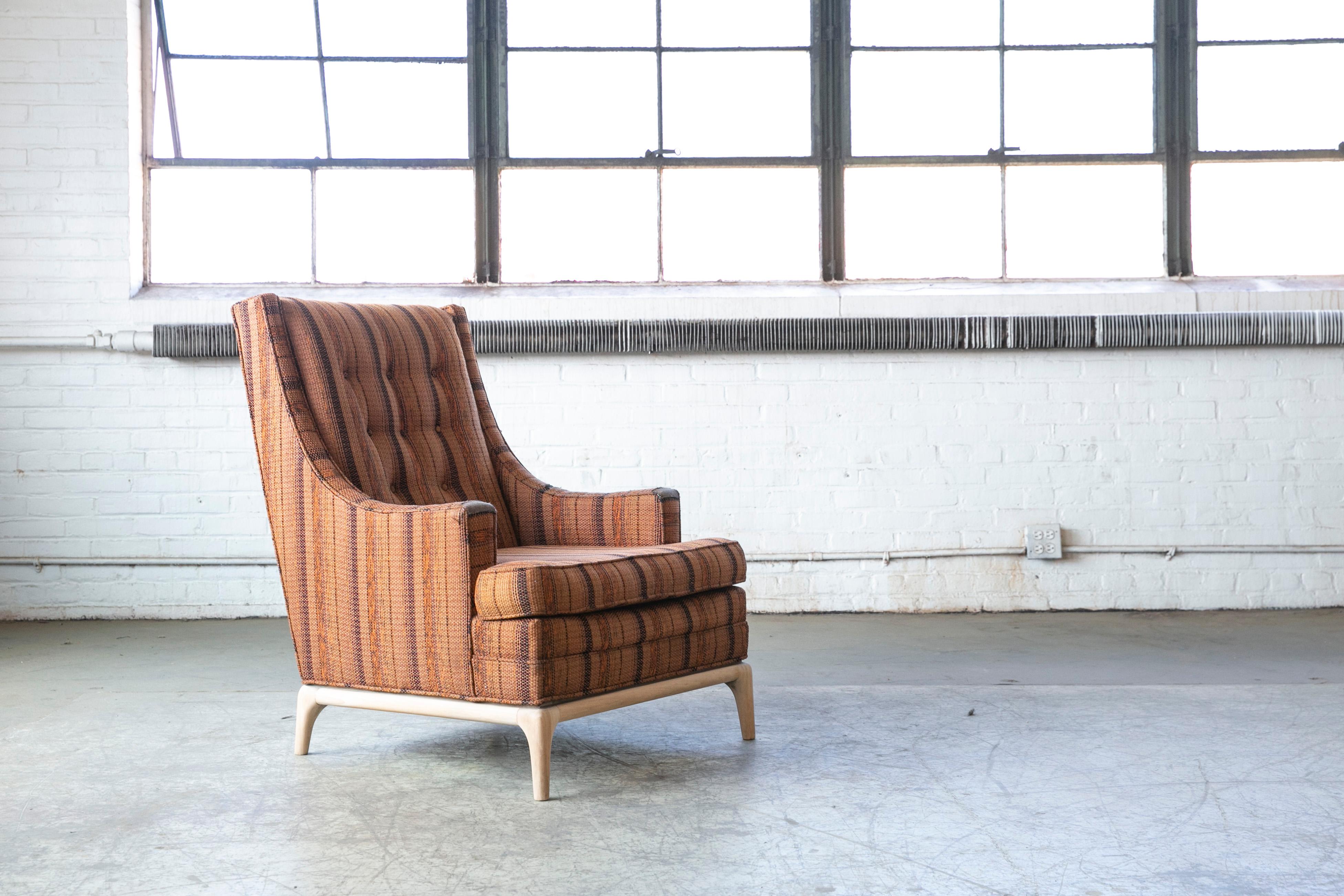 Elegant American 1950's lounge chair with mahogany base in the manner of T.H. Robsjohn- Gibbings. Beautifully made but we are unaware of the maker and Designer. We have sanded the mahogany base to a neutral and more modern finish. We love the