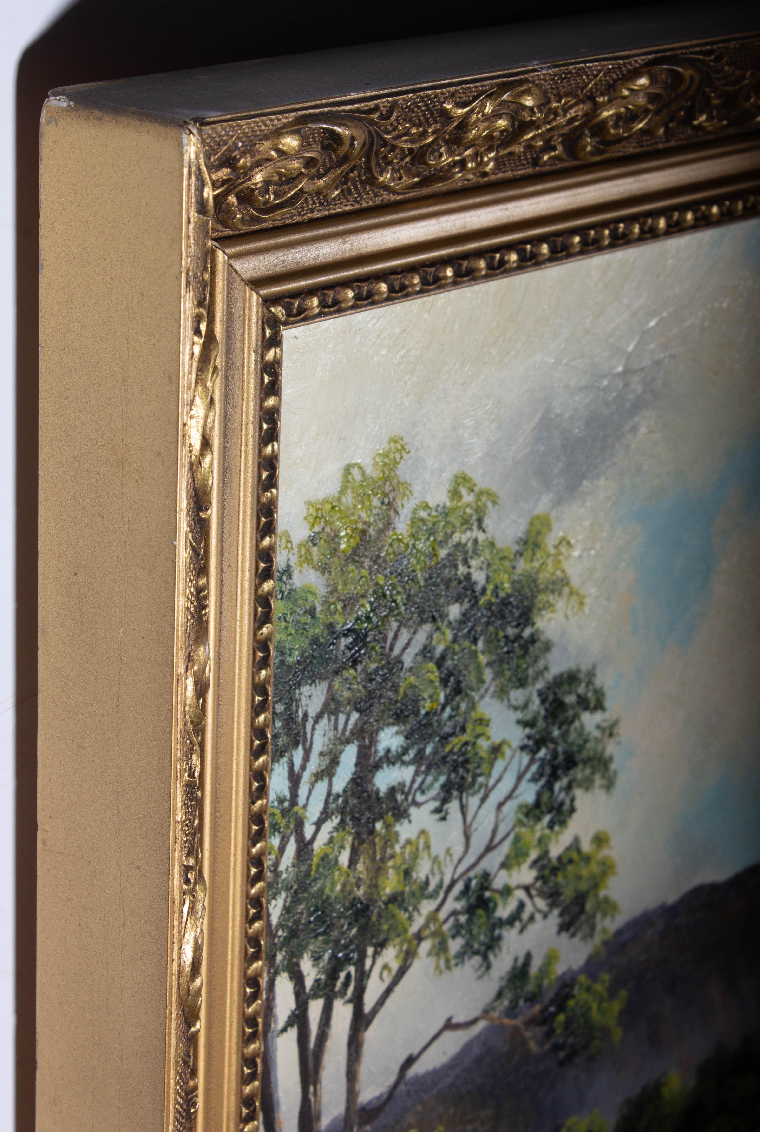 A fine mid Century oil landscape showing a glassy lake reflecting the hazy purple mountains in the distance. The artist has signed to the lower left and the painting has been presented in a foliate gilt frame with scrolling acanthus leaf
