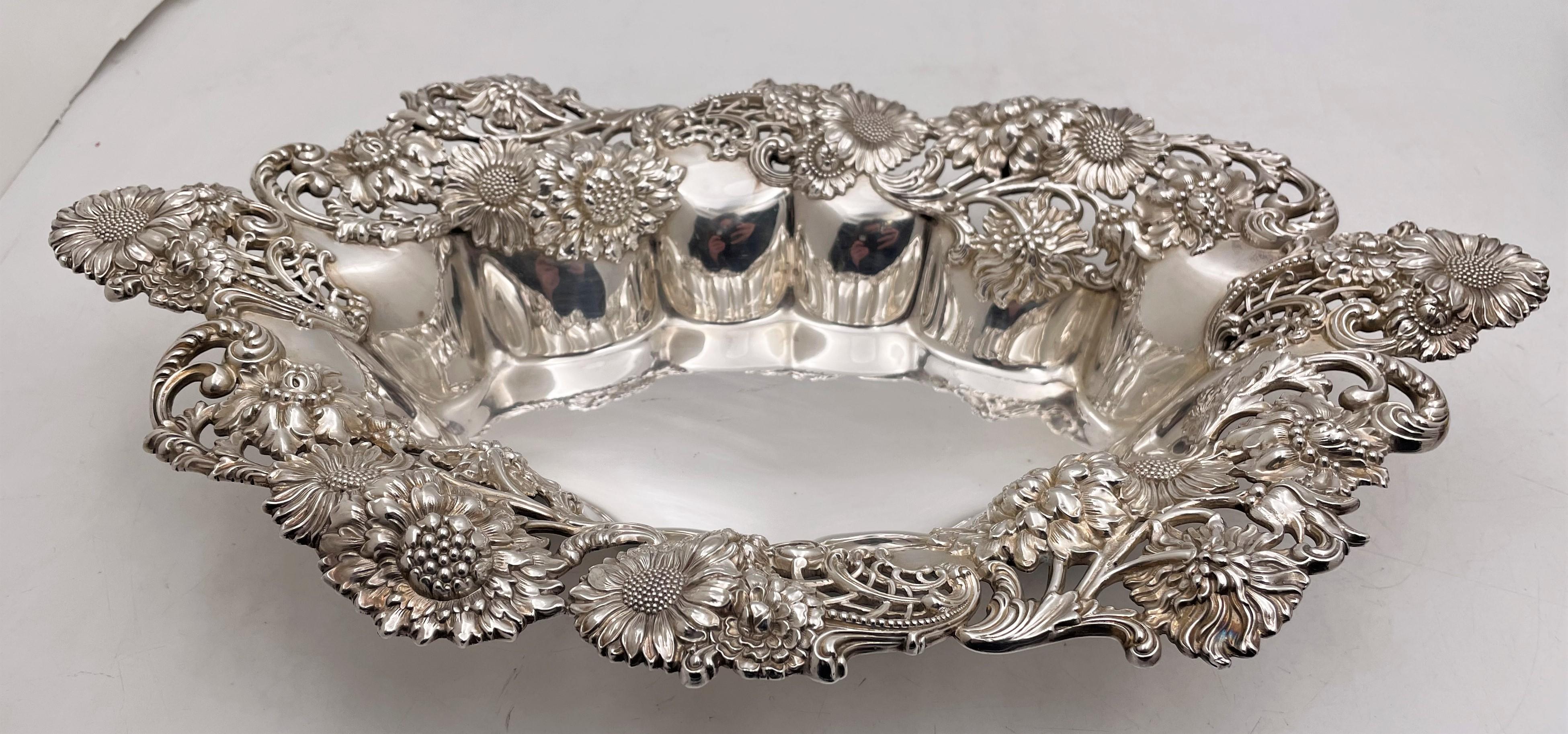 Theodore B. Starr sterling silver centerpiece bowl from the early 20th century in Art Nouveau style with exquisite, raised flowers, including daisies, as well as curvilinear motifs accentuating the multilobed shape of the bowl. It measures 15 1/8''