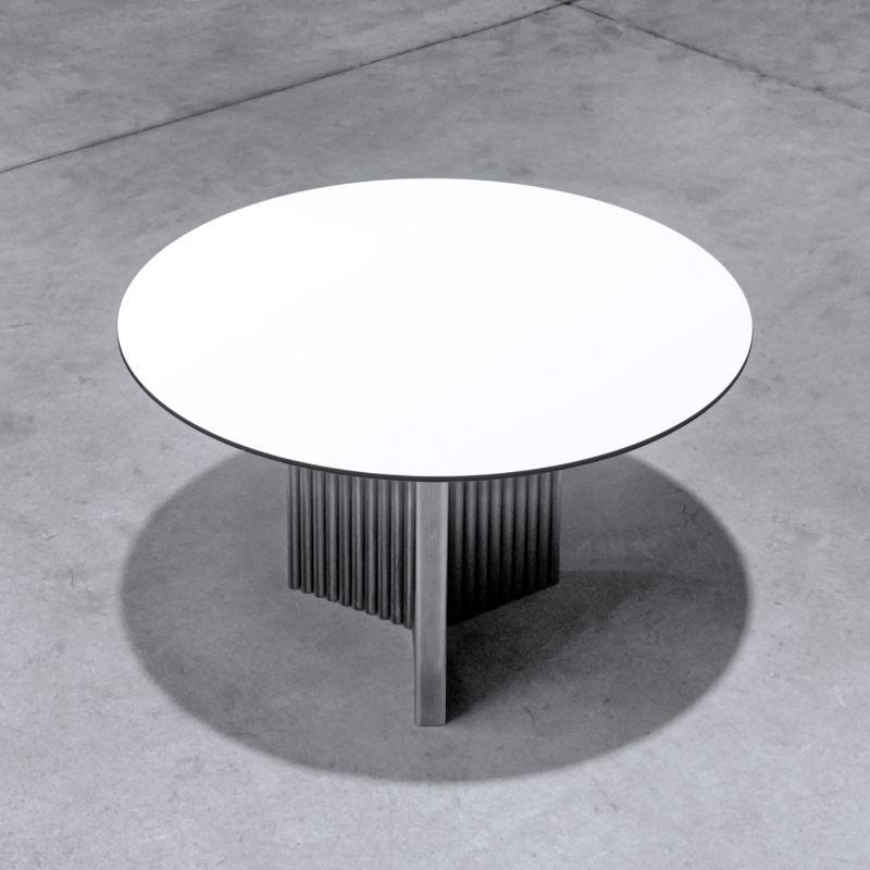 A wide and eccentric-looking table characterized by a 3-pointed star shaped central leg. The orientation of the table around its own axis generates ever-new shapes and perspectives that blend with the domestic spaces. The table top is made of